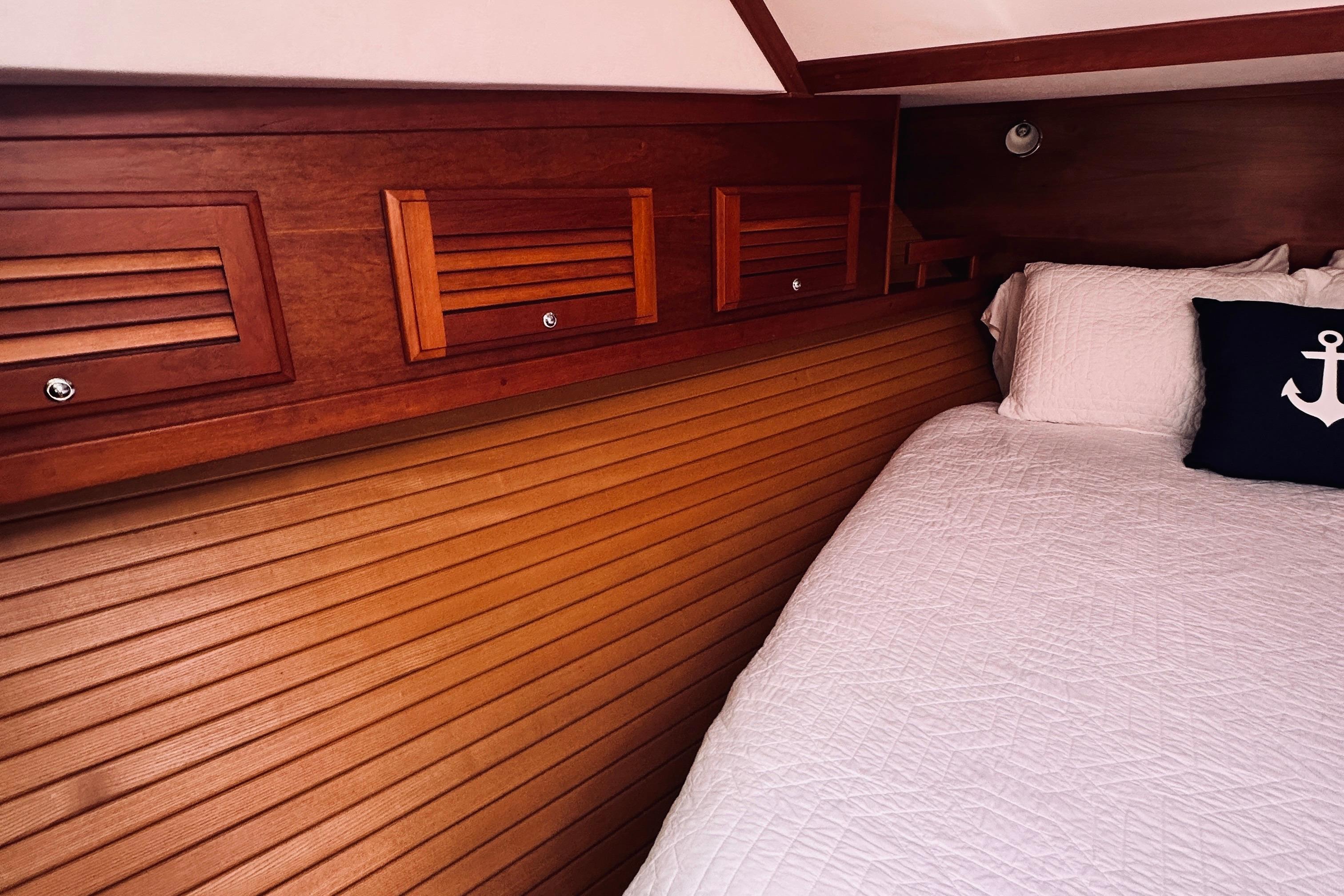 Cozy cabin interior of 2007 Sabreline 34 Express with wood paneling and nautical decor.