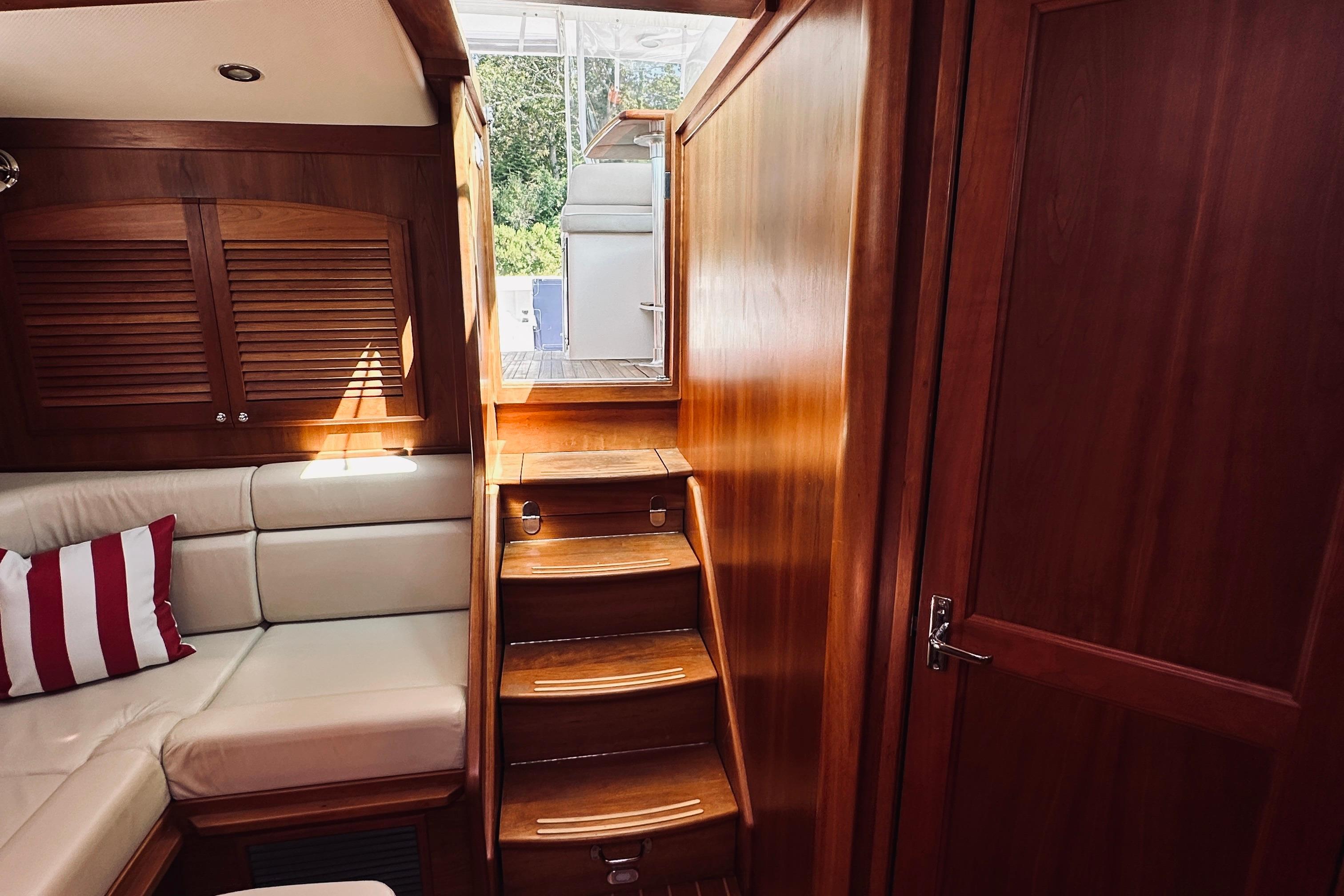 Interior of 2007 Sabreline 34 Express yacht with wooden finish and cozy seating.