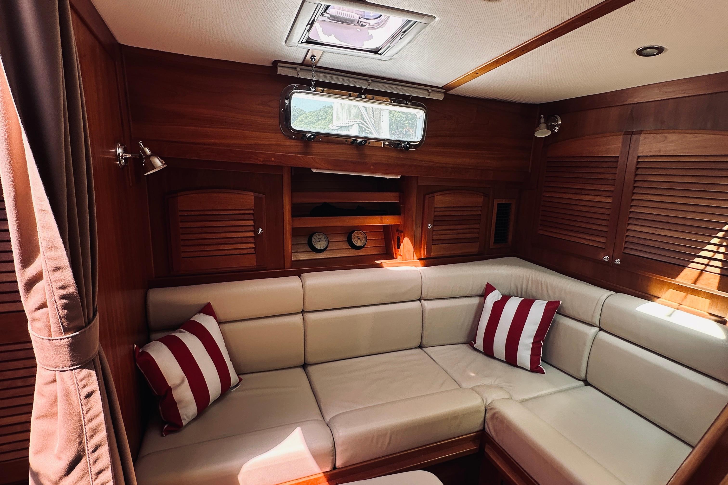 Luxurious interior of 2007 Sabreline 34 Express yacht with plush seating and striped cushions.