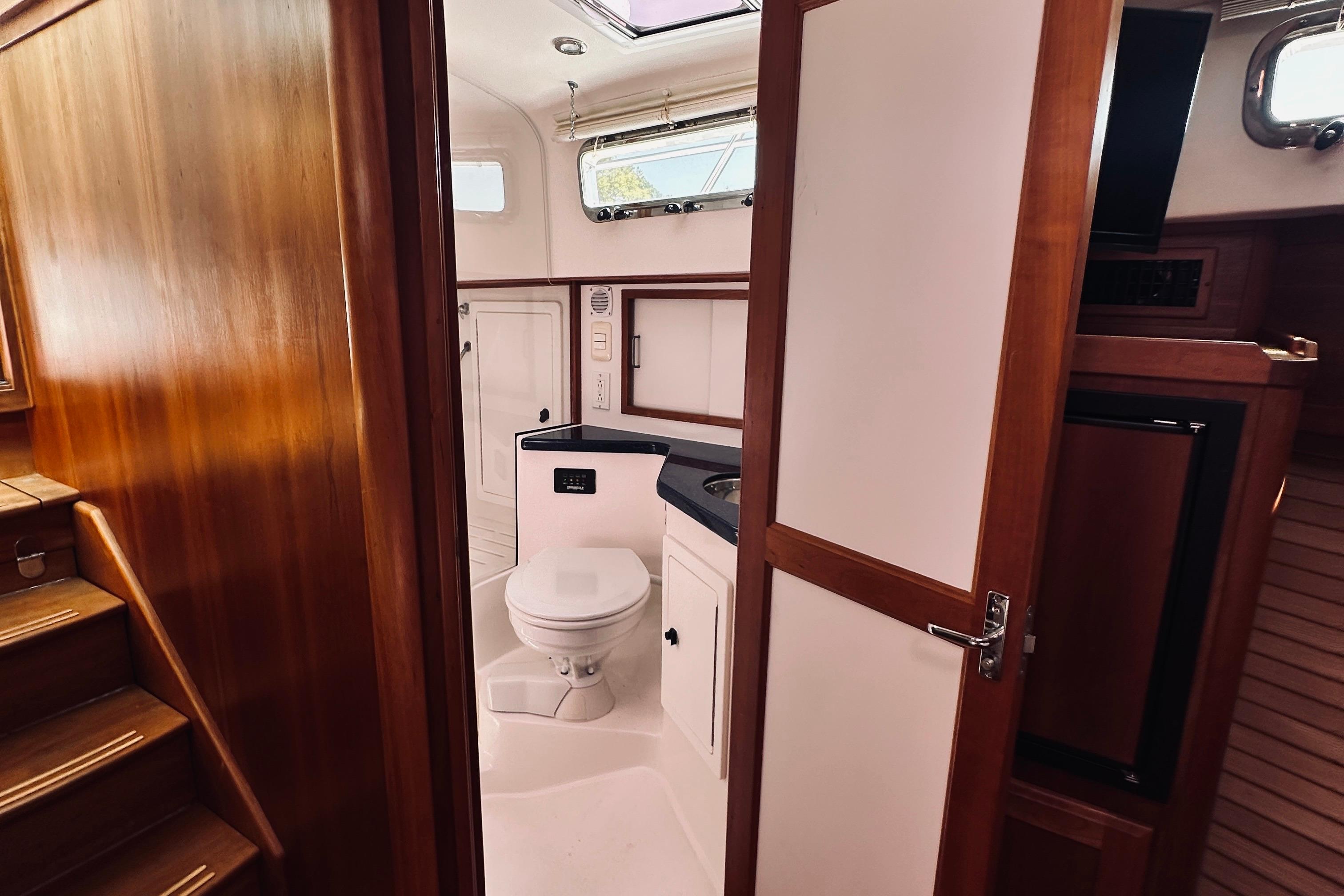 2007 Sabreline 34 Express yacht interior with wooden finish and compact bathroom.