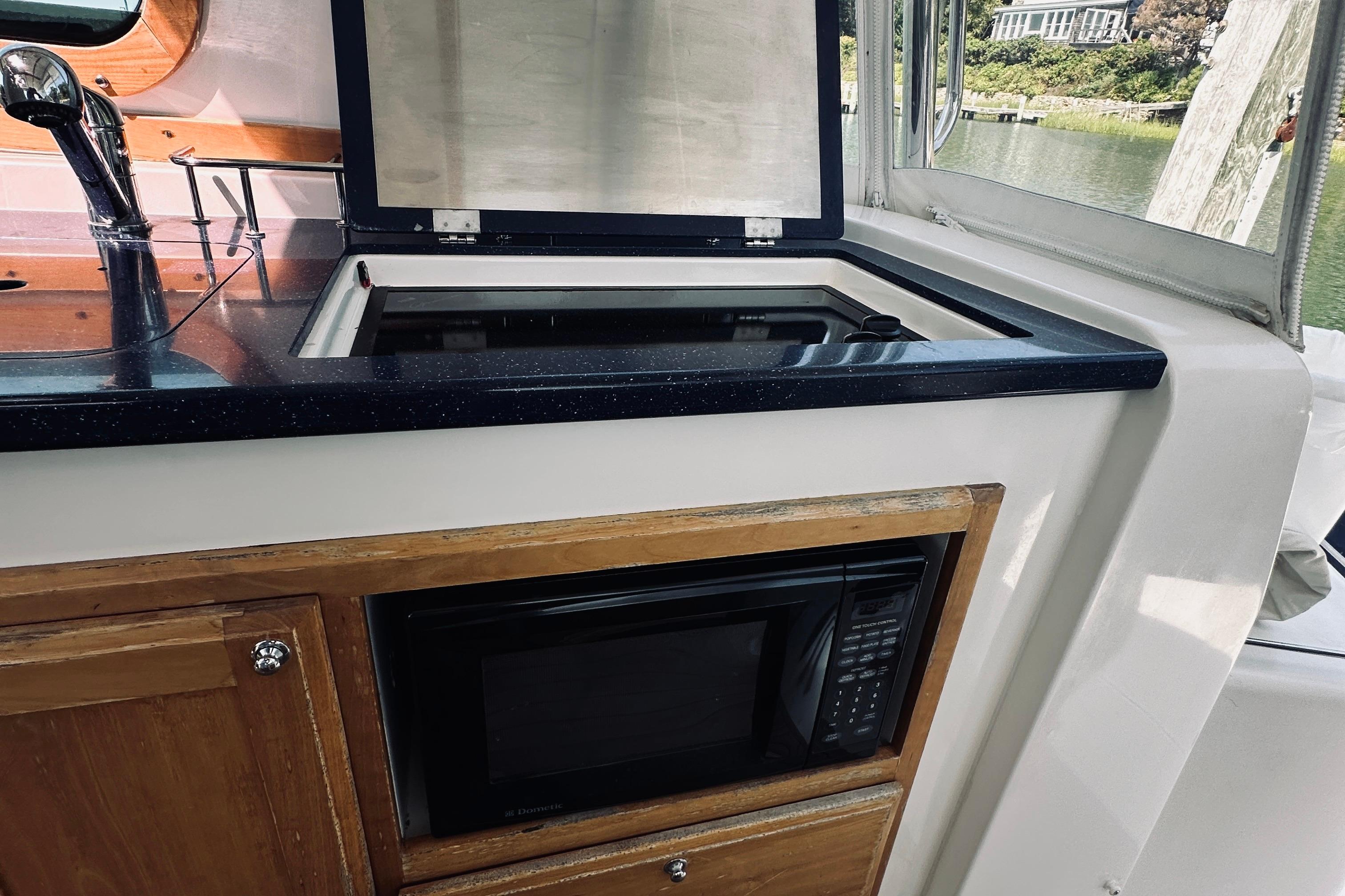 Kitchen area of 2007 Sabreline 34 Express boat with sink and microwave.