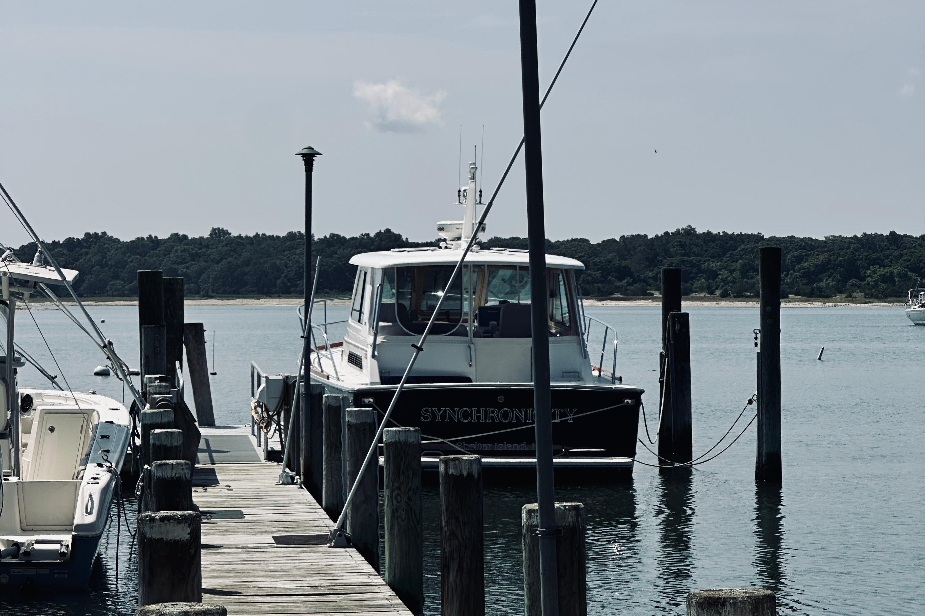 2007 Sabreline 34 Express docked at a marina, surrounded by calm waters and trees.