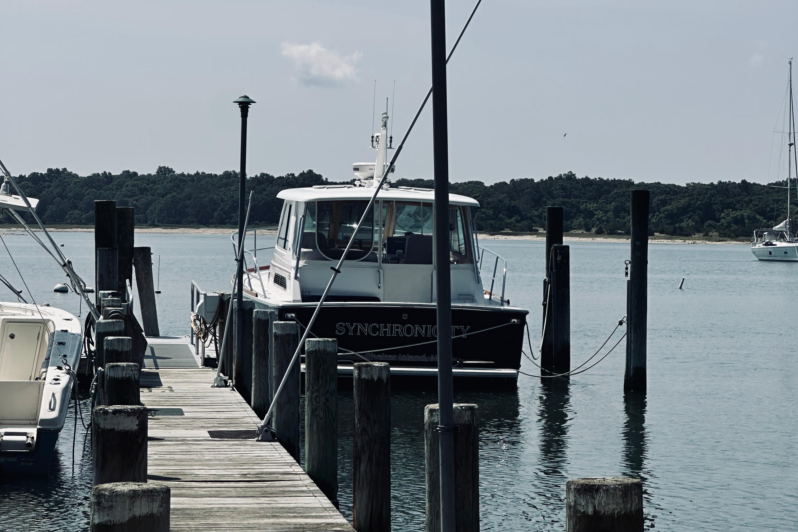 2007 Sabreline 34 Express boat docked at a marina with scenic background.