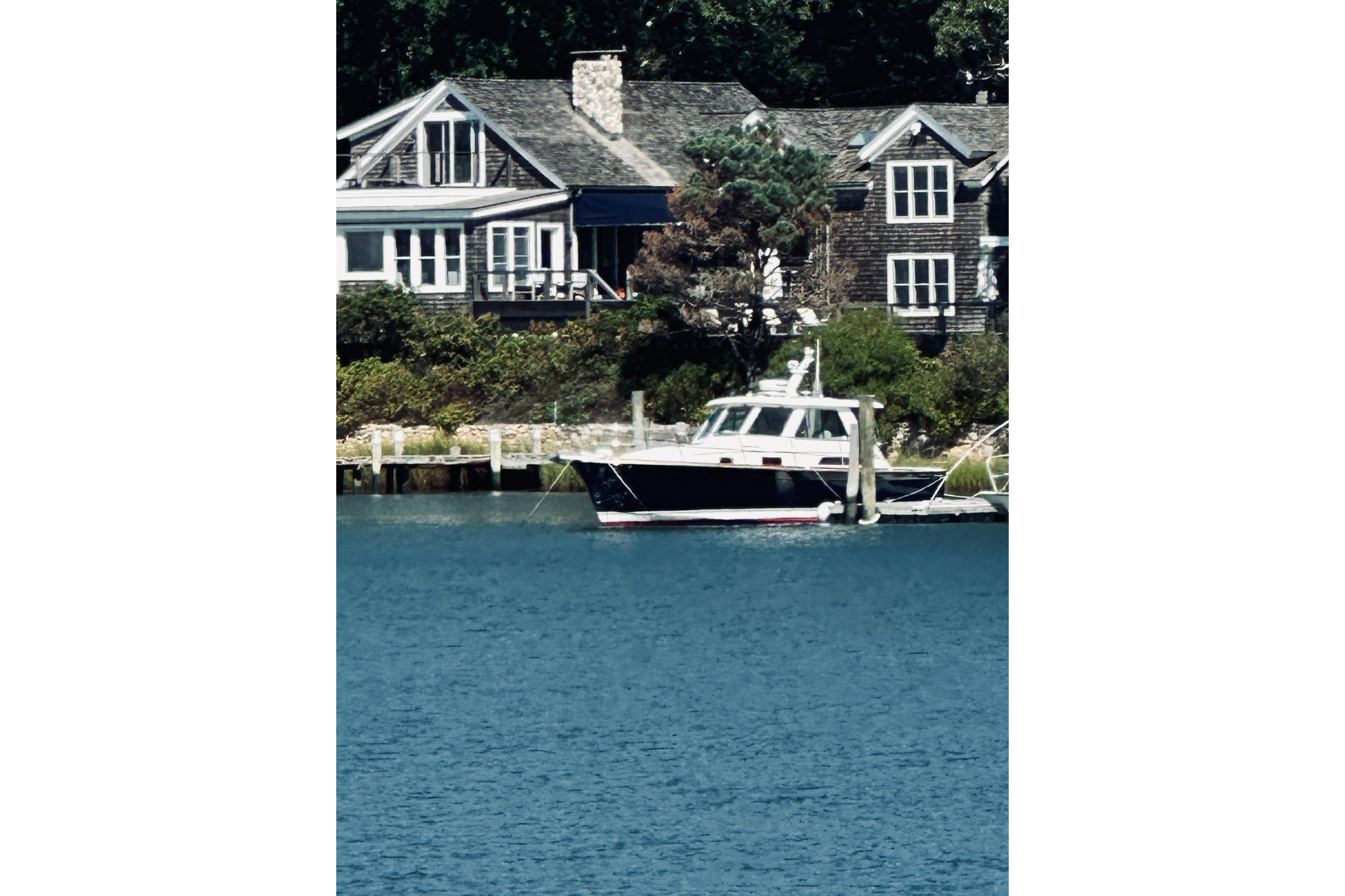 2007 Sabreline 34 Express yacht docked near charming waterfront homes.