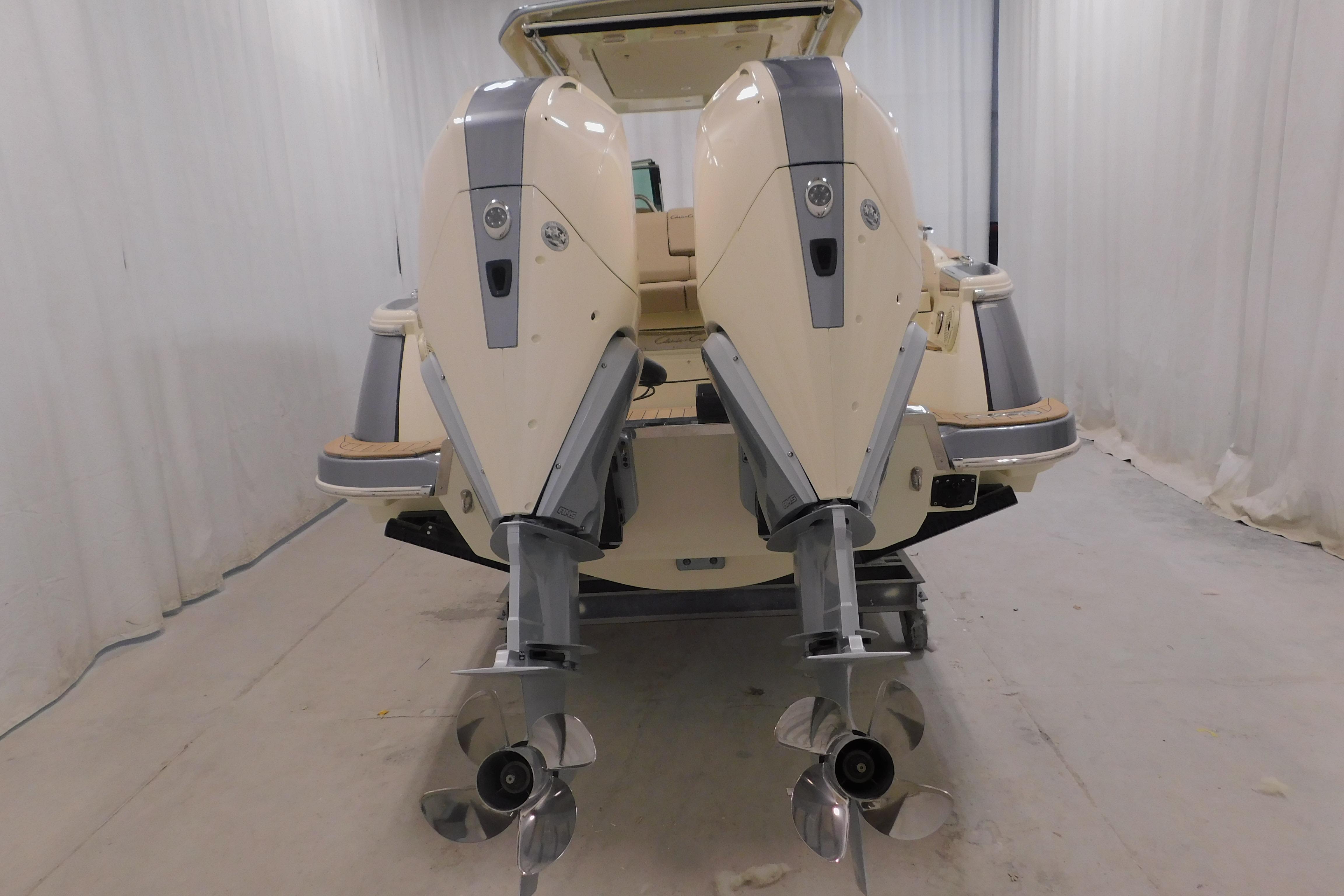 2024 Chris-Craft Launch 31 GT boat with dual outboard engines in a showroom.