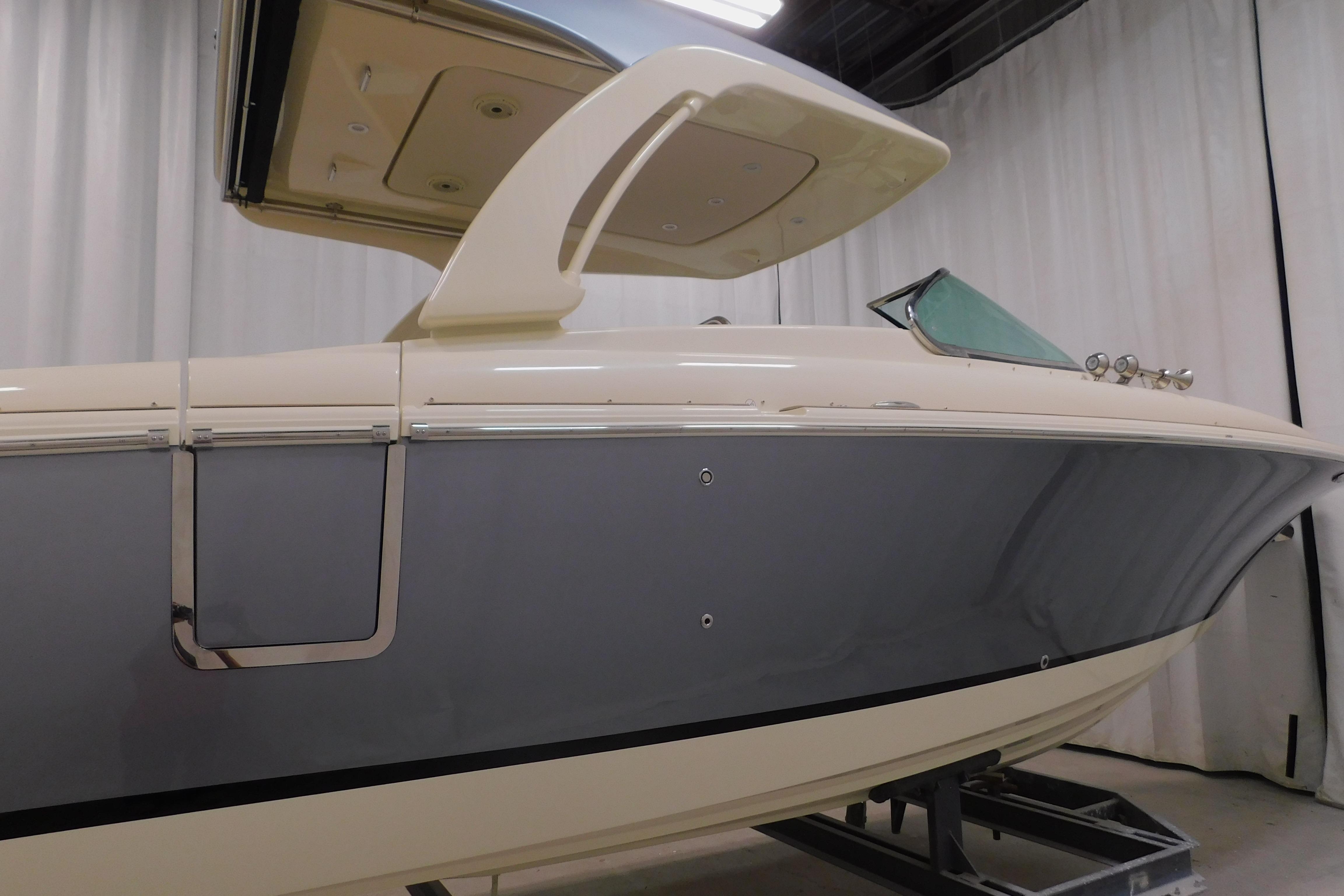 2024 Chris-Craft Launch 31 GT boat in showroom, side view with sleek design.