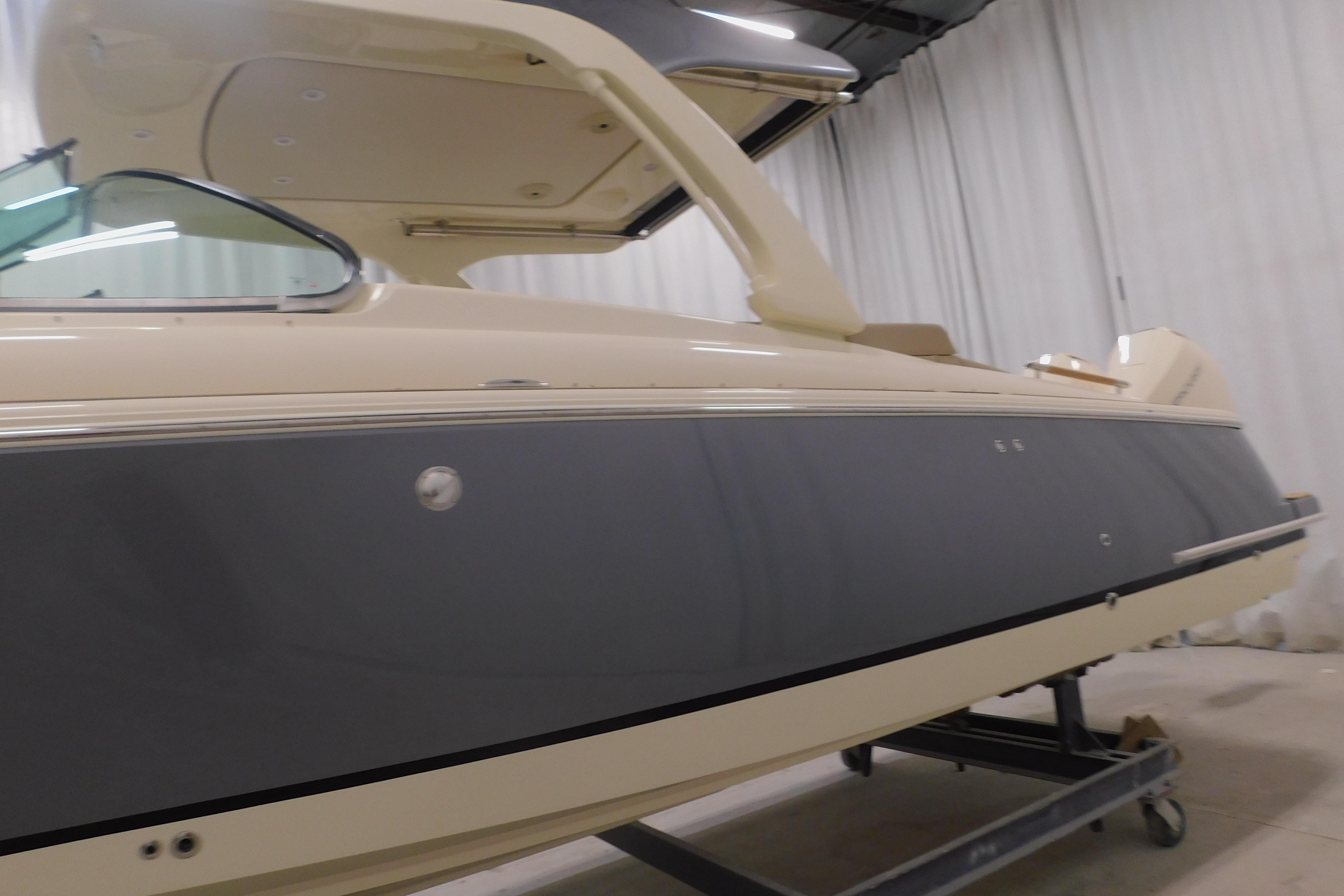 2024 Chris-Craft Launch 31 GT boat in showroom, side view with sleek design.