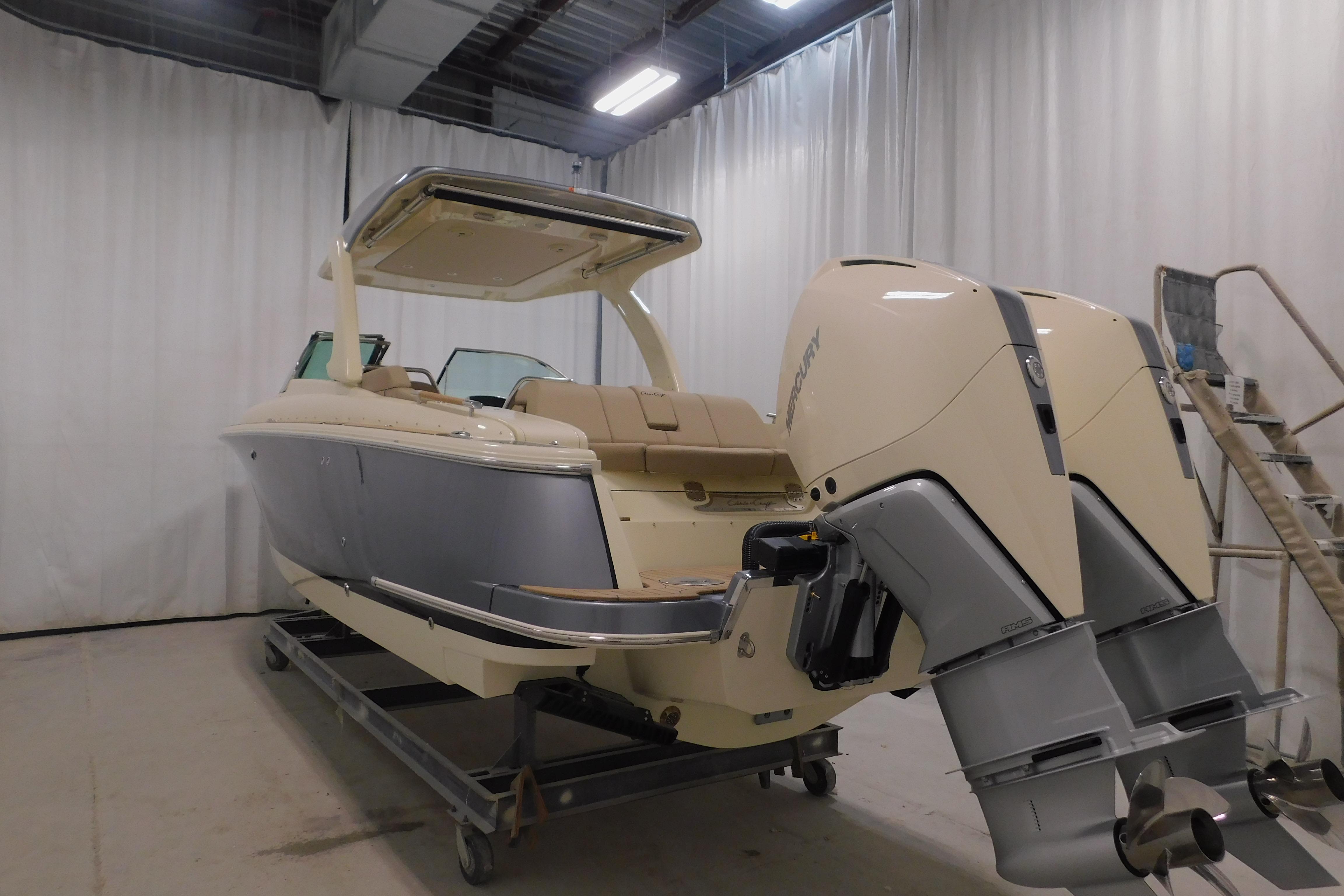 2024 Chris-Craft Launch 31 GT boat with dual Mercury outboard engines in a showroom.