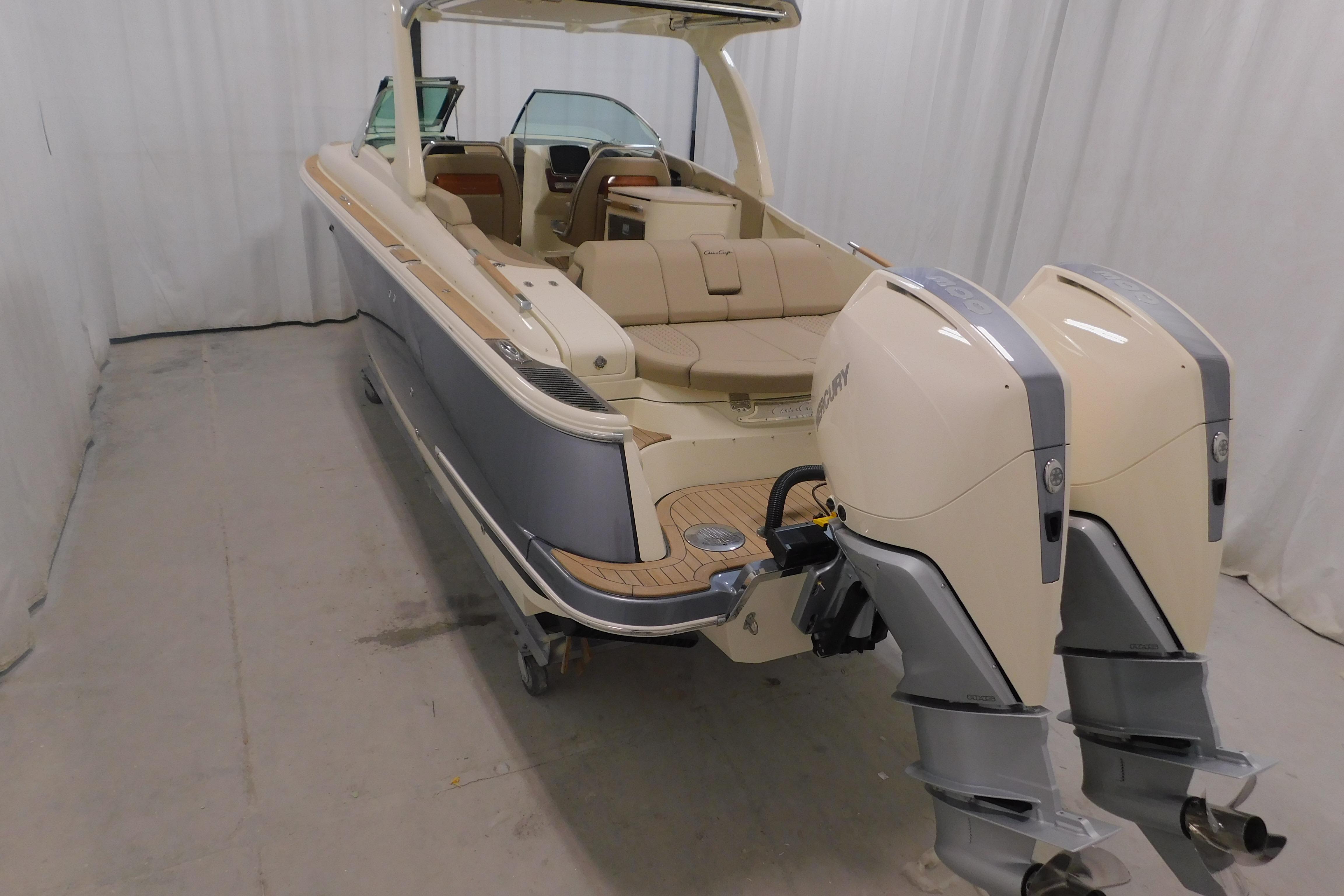 2024 Chris-Craft Launch 31 GT boat with dual outboard engines in a showroom.