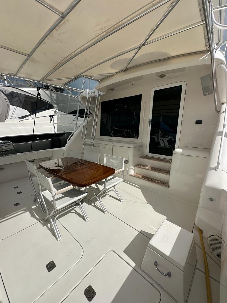 Bertram-510 Convertible 2002 -PR-2002 Bertram 510 Convertible yacht with shaded outdoor seating area and table.-9177717 | Thumbnail