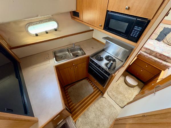 1998 Bayliner 3388 Command Bridge Motoryacht kitchen with stove, microwave, and sink.