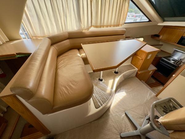 Interior of 1998 Bayliner 3388 Command Bridge Motoryacht with dining area and kitchenette.