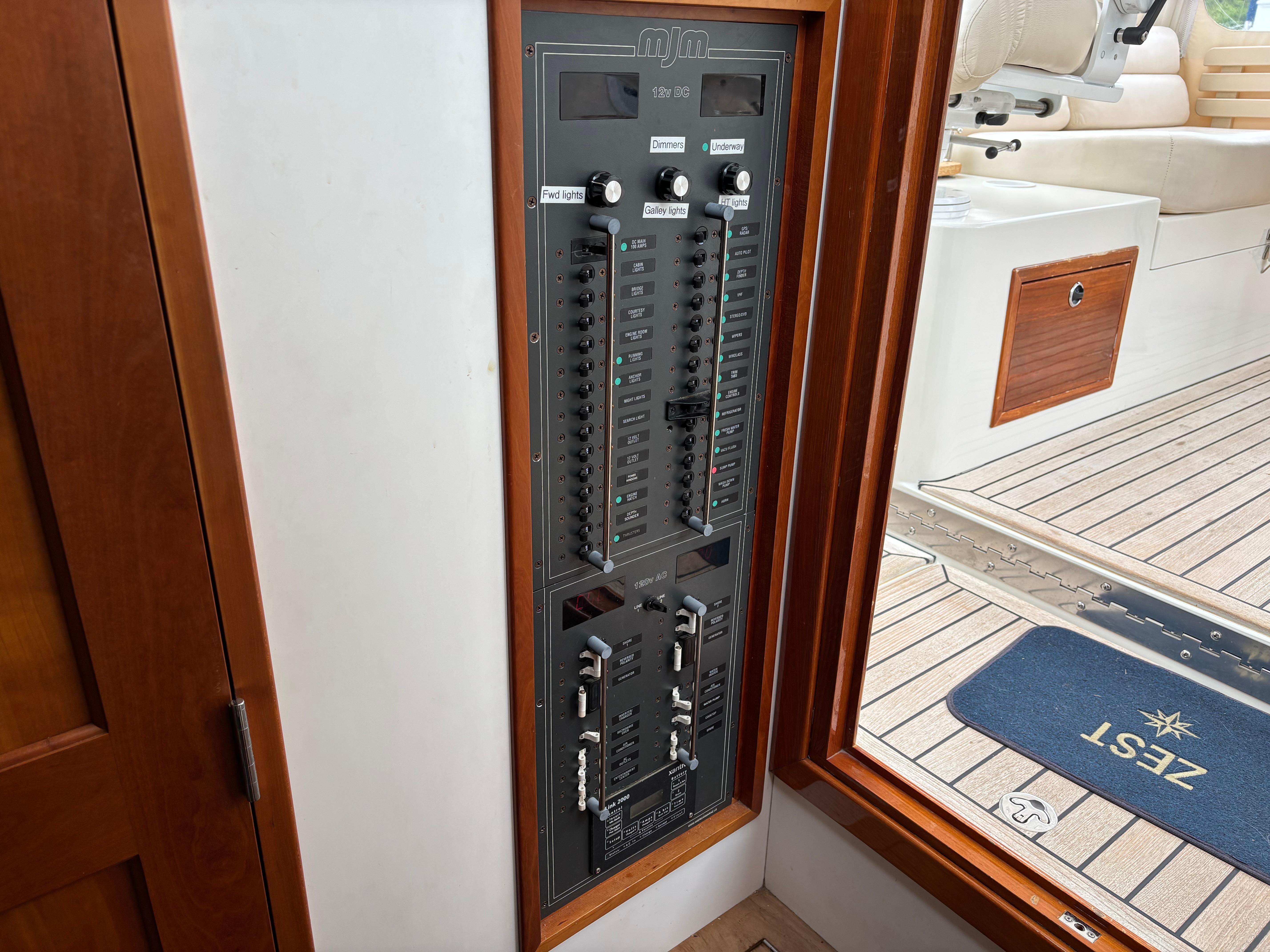 MJM-34z Express HT 2006-Zest MD-US-Electrical panel inside a 2006 MJM 34z Express HT boat, near wooden door and deck.-9817750 | Thumbnail