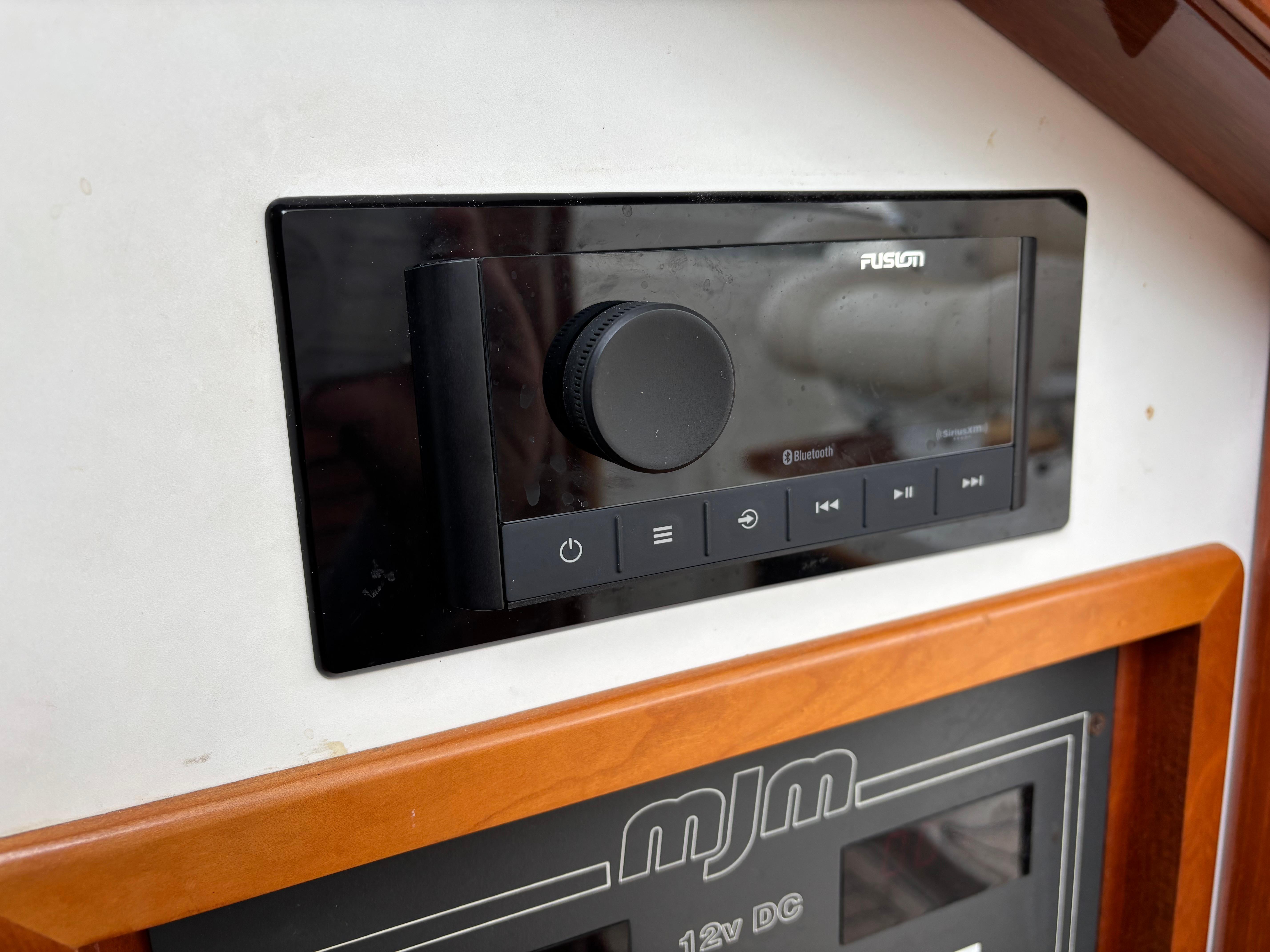 MJM-34z Express HT 2006-Zest MD-US-Control panel of a 2006 MJM 34z Express HT boat with Fusion audio system.-9817750 | Thumbnail