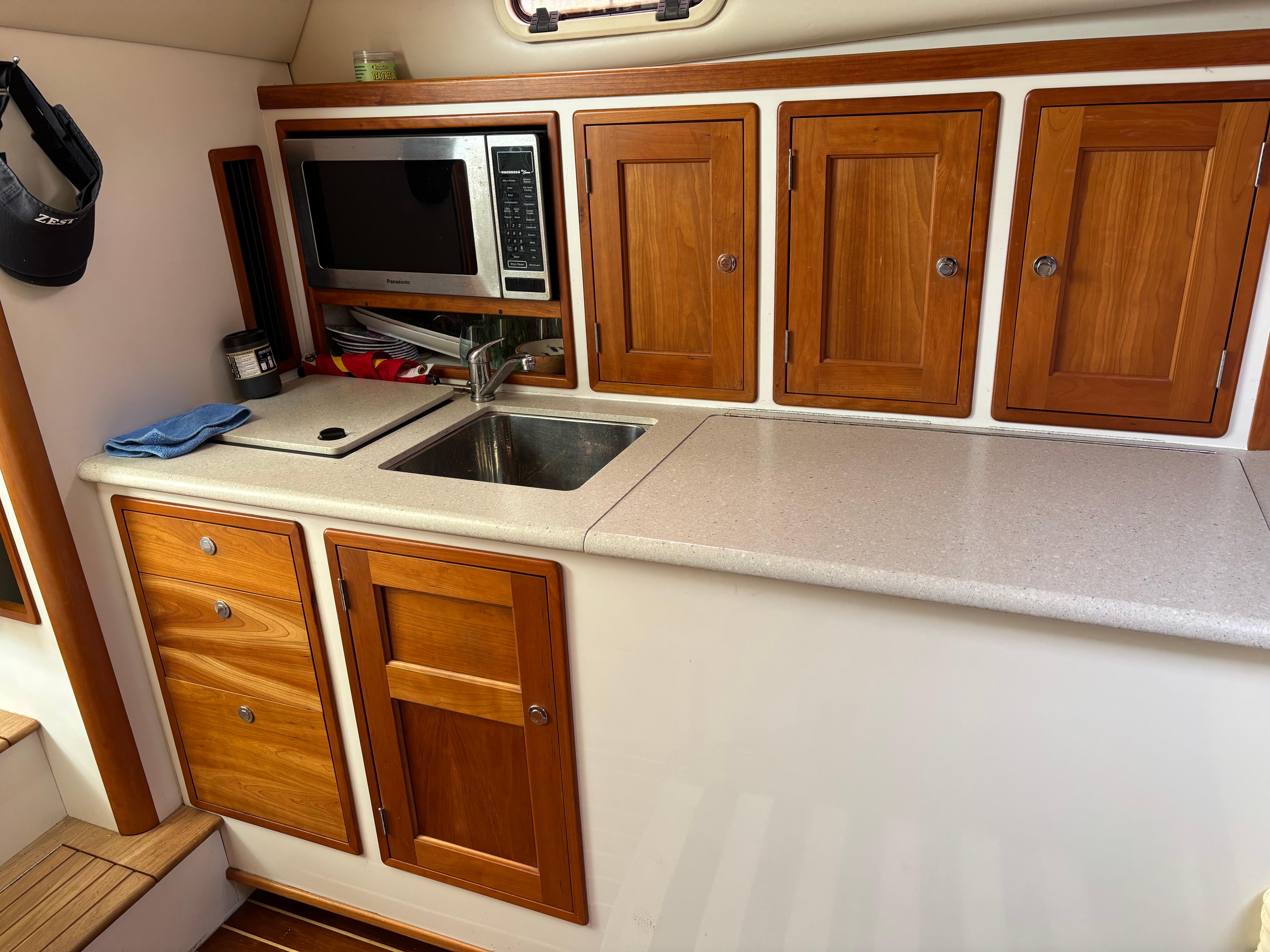 MJM-34z Express HT 2006-Zest MD-US-2006 MJM 34z Express HT yacht kitchen with wooden cabinets, sink, and microwave.-9817750 | Thumbnail