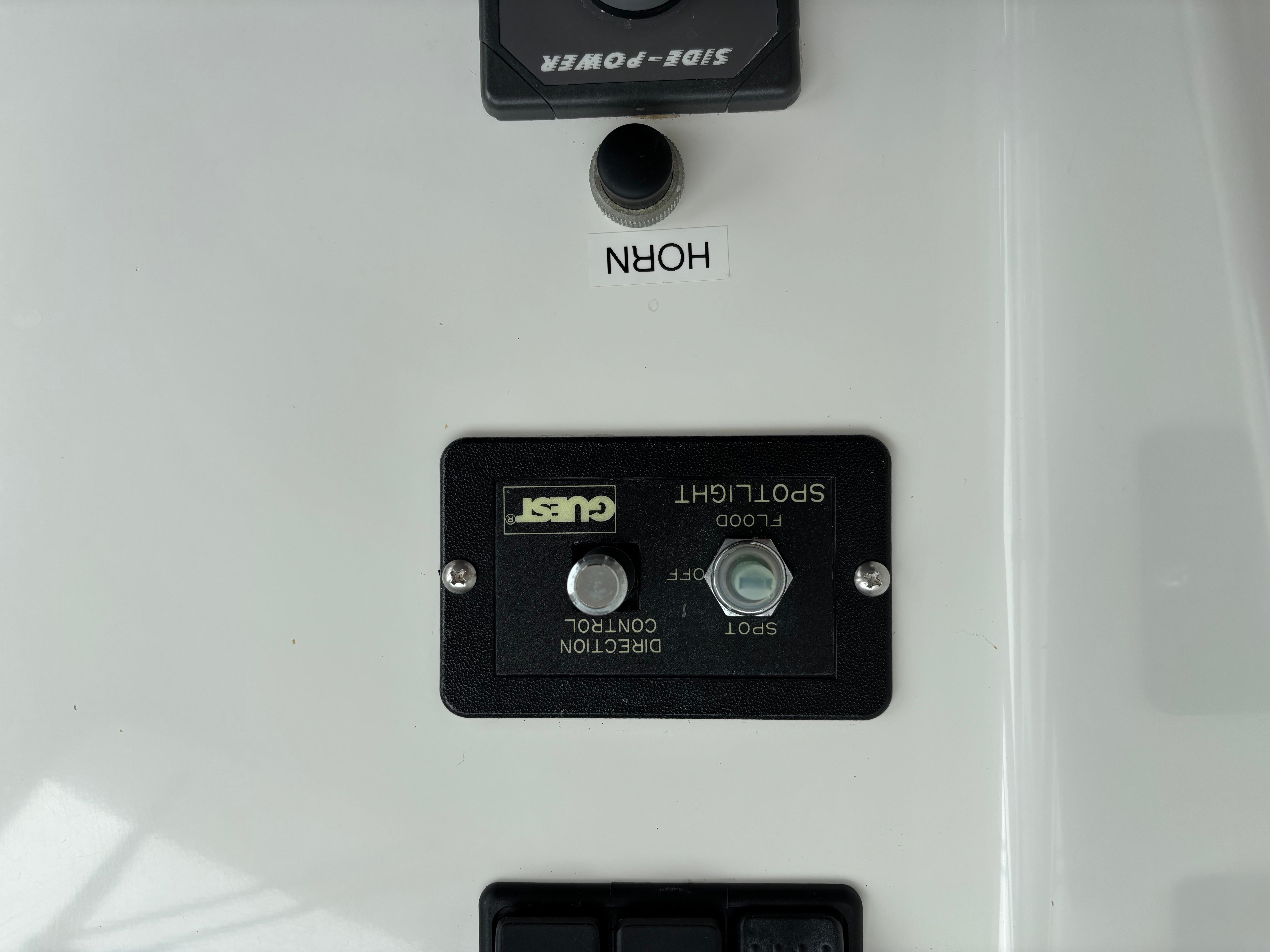 MJM-34z Express HT 2006-Zest MD-US-Control panel of a 2006 MJM 34z Express HT boat with spotlight and horn buttons.-9817750 | Thumbnail