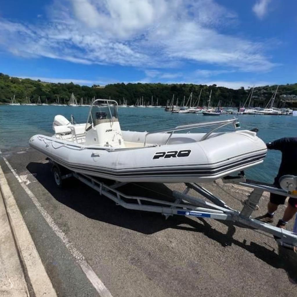 2005 Zodiac Pro Open 650 boat on trailer by scenic waterfront.