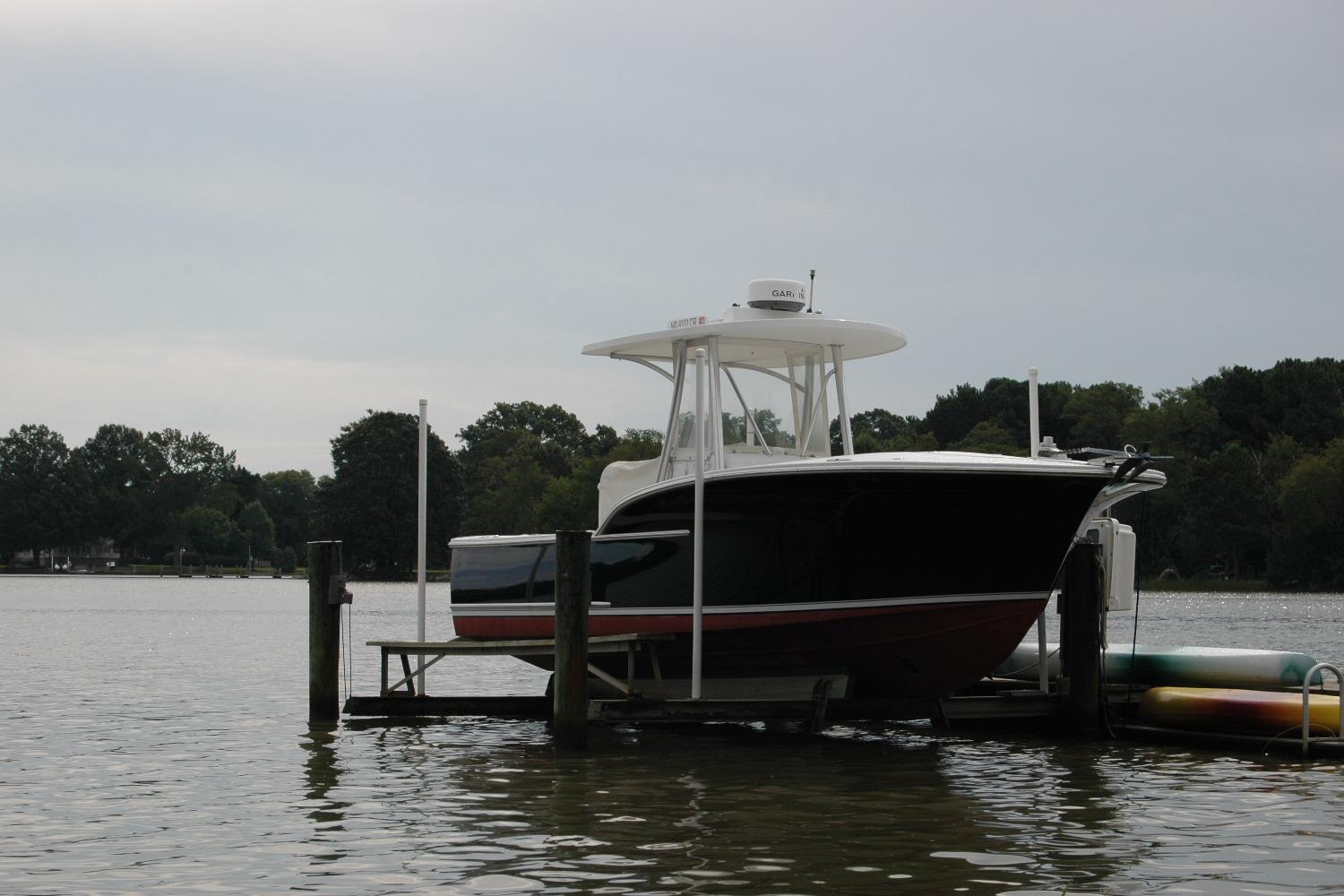 2013 Composite Yacht 26 docked on a calm lake with trees in the background.