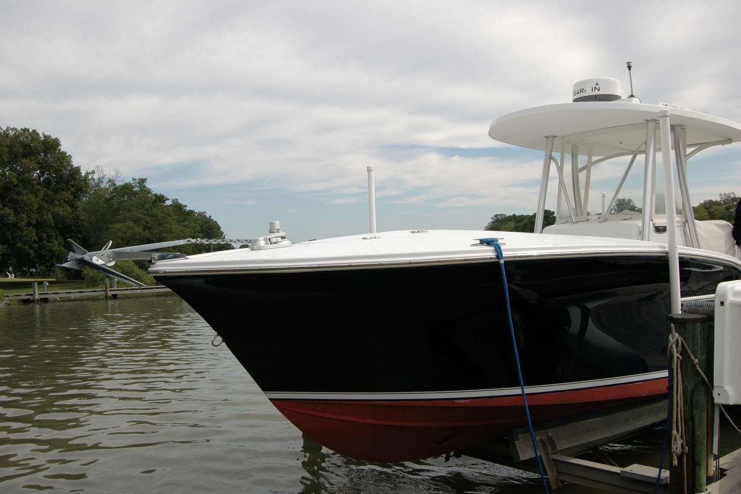 2013 Composite Yacht 26 docked on calm water under a cloudy sky.