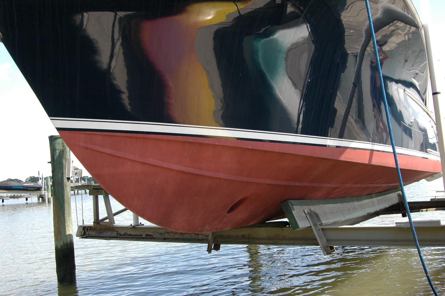 2013 Composite Yacht 26 on lift, showcasing hull design and vibrant colors.