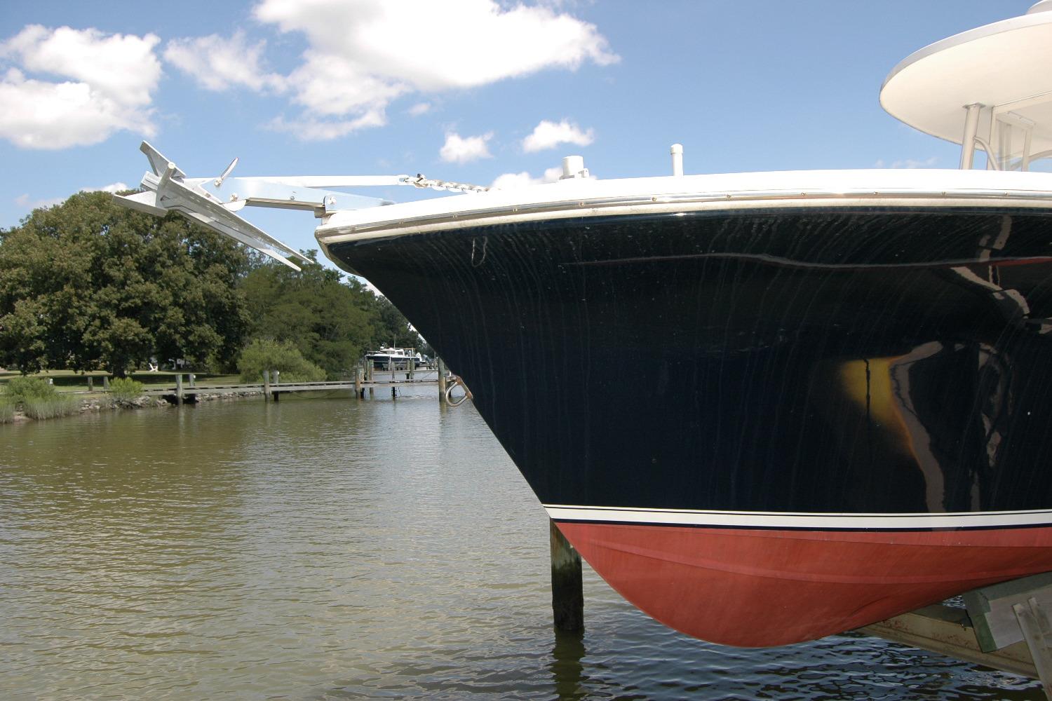 2013 Composite Yacht 26 docked on a calm river under a clear blue sky.