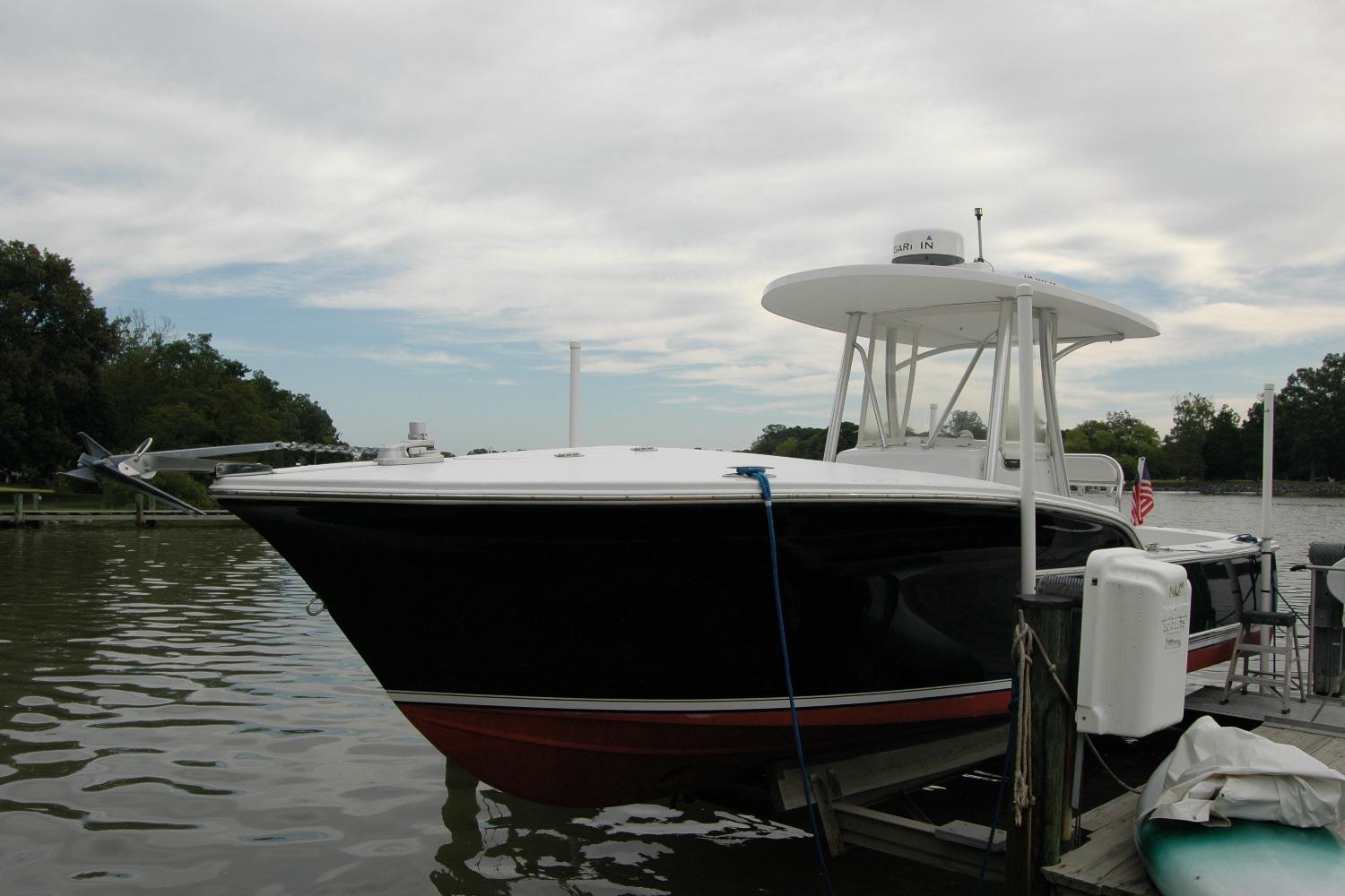 2013 Composite Yacht 26 docked on a calm river under a cloudy sky.