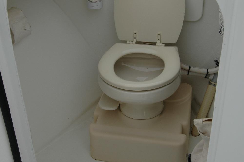Compact marine toilet in a 2013 Composite Yacht 26, featuring a clean, white design.