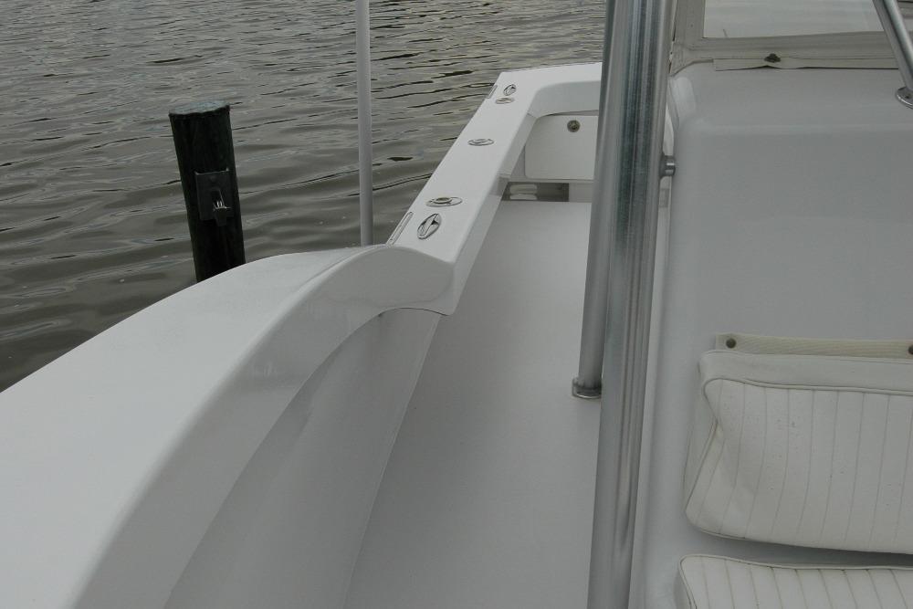 2013 Composite Yacht 26 interior with white seating and railing, docked by water.