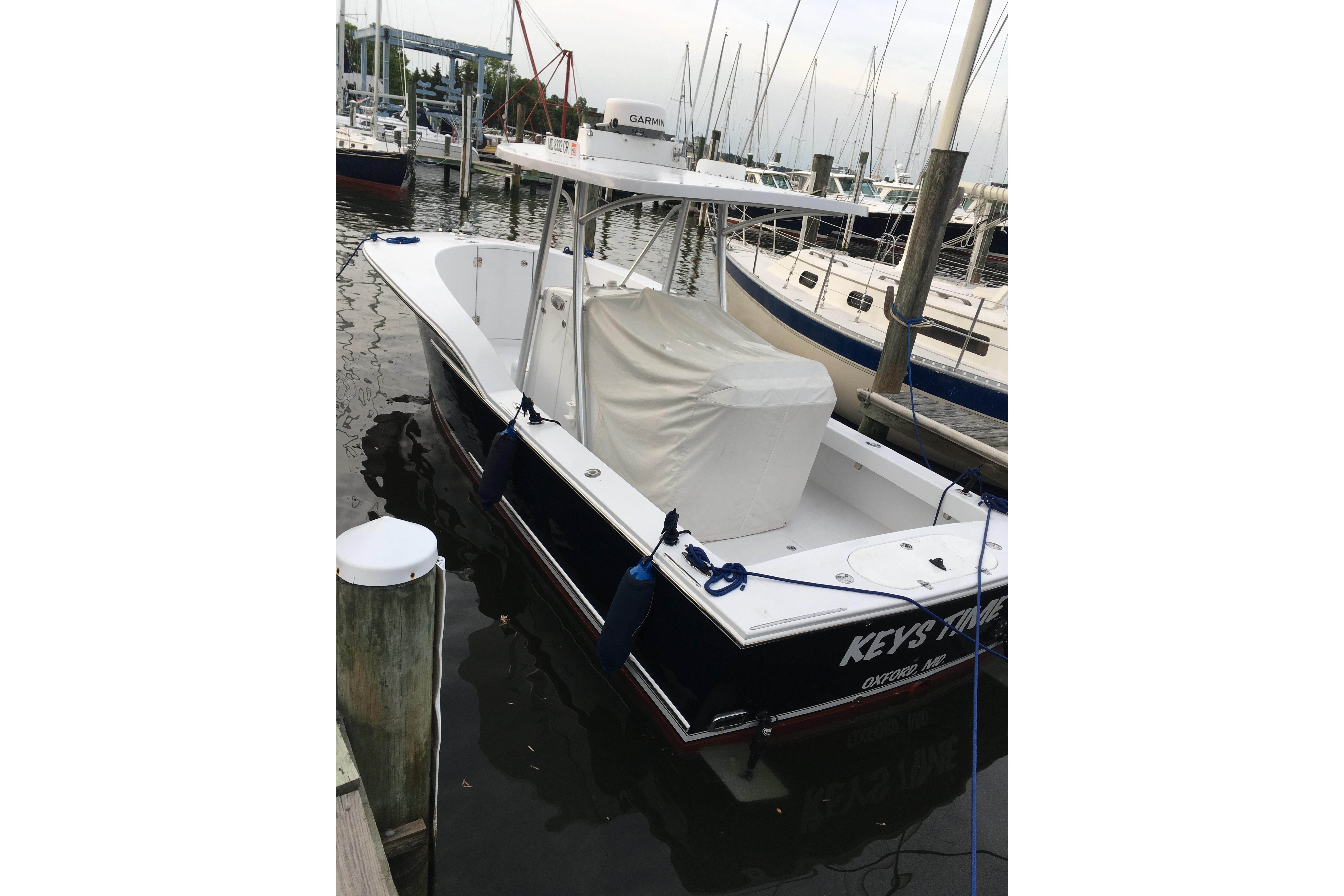 2013 Composite Yacht 26 docked in marina, featuring sleek design and covered seating area.