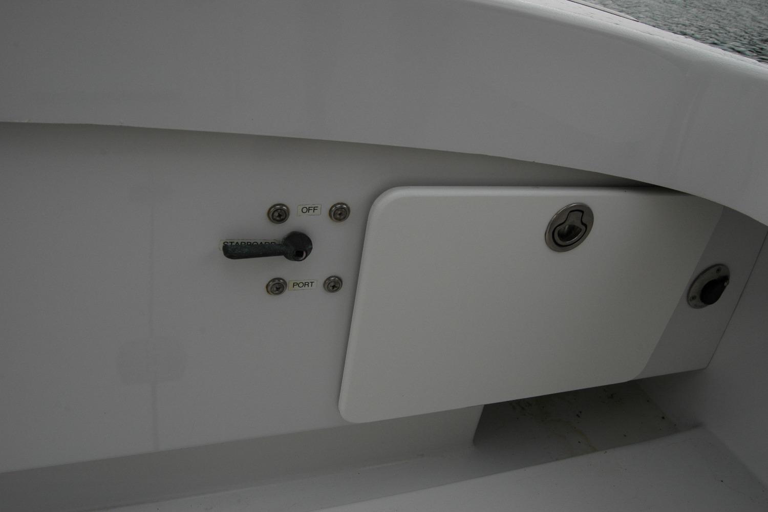 Control panel on a 2013 Composite Yacht 26, featuring switches and storage compartment.