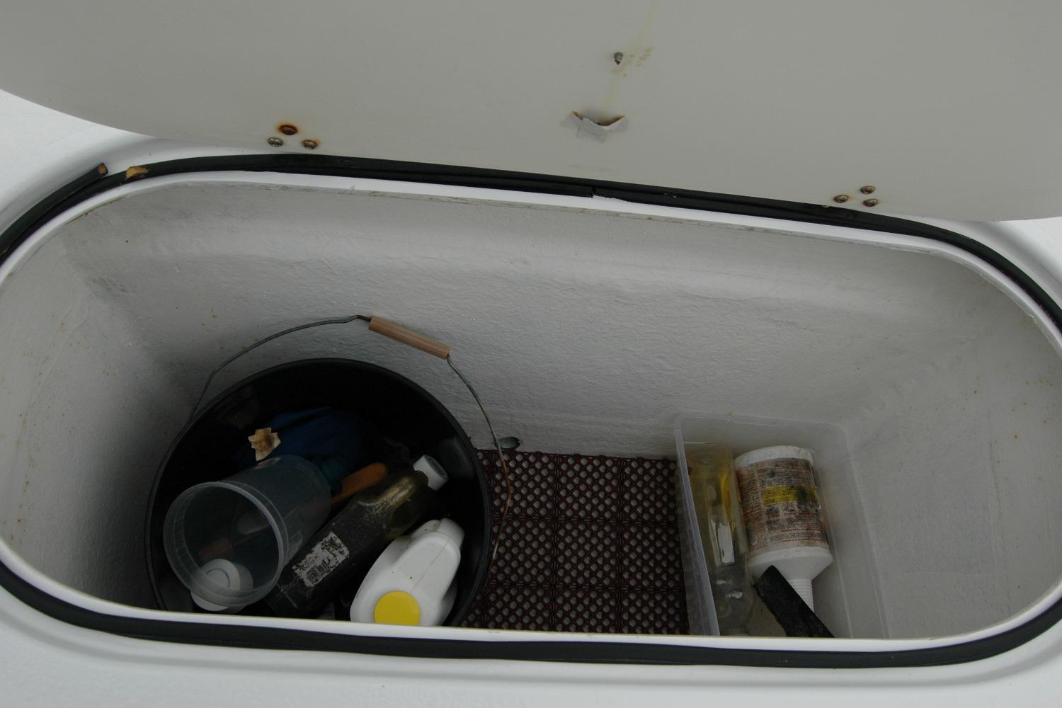 Storage compartment on 2013 Composite Yacht 26 with cleaning supplies and tools.