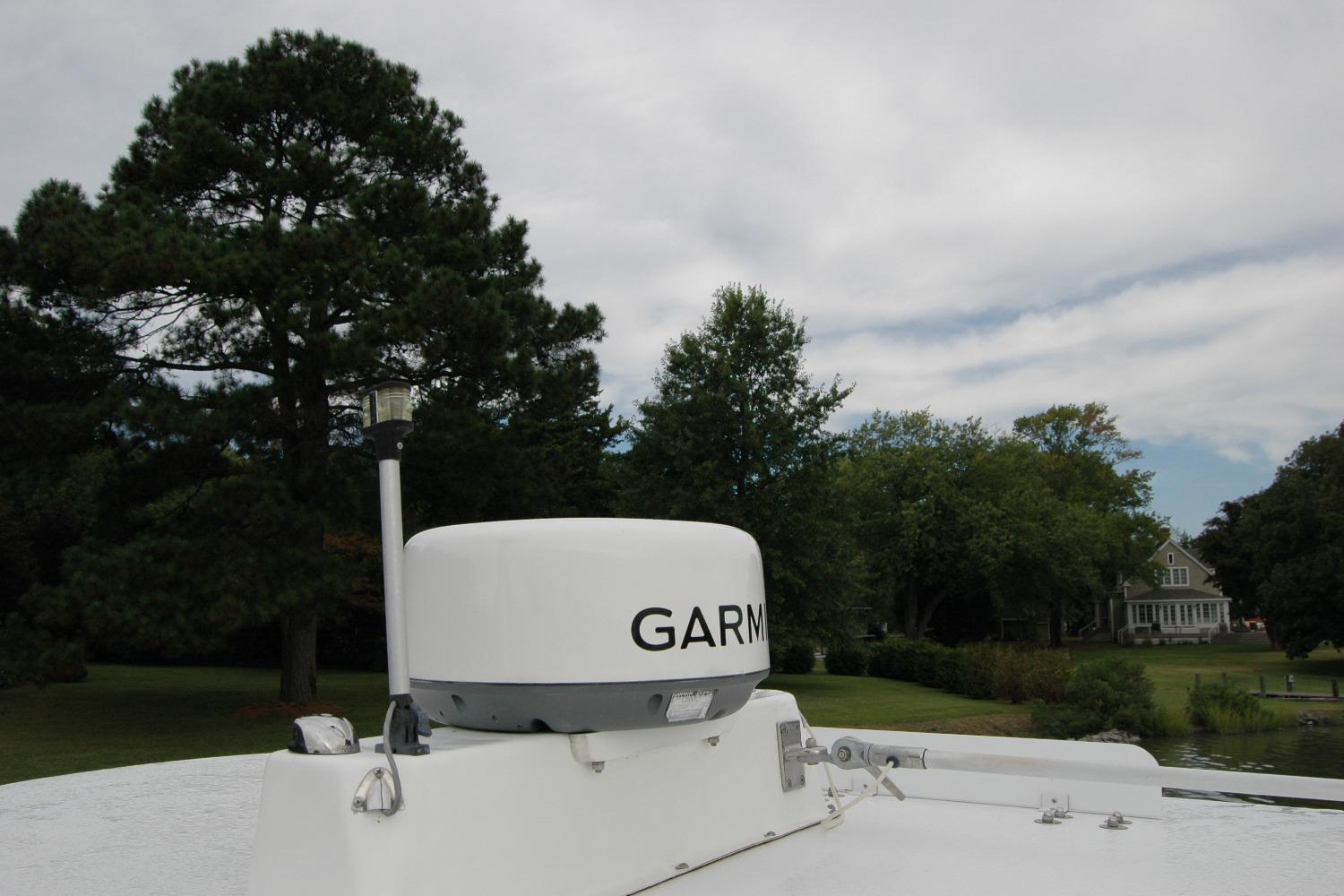 Radar equipment on 2013 Composite Yacht 26, surrounded by trees and a house in the background.