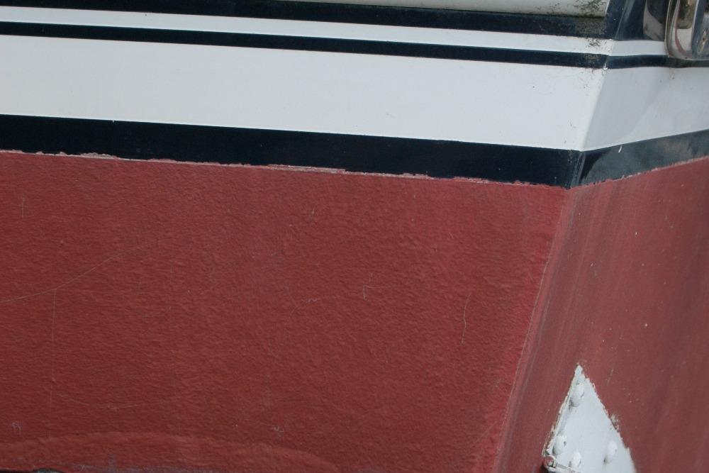 Close-up of 2013 Composite Yacht 26 hull with red and white paint.