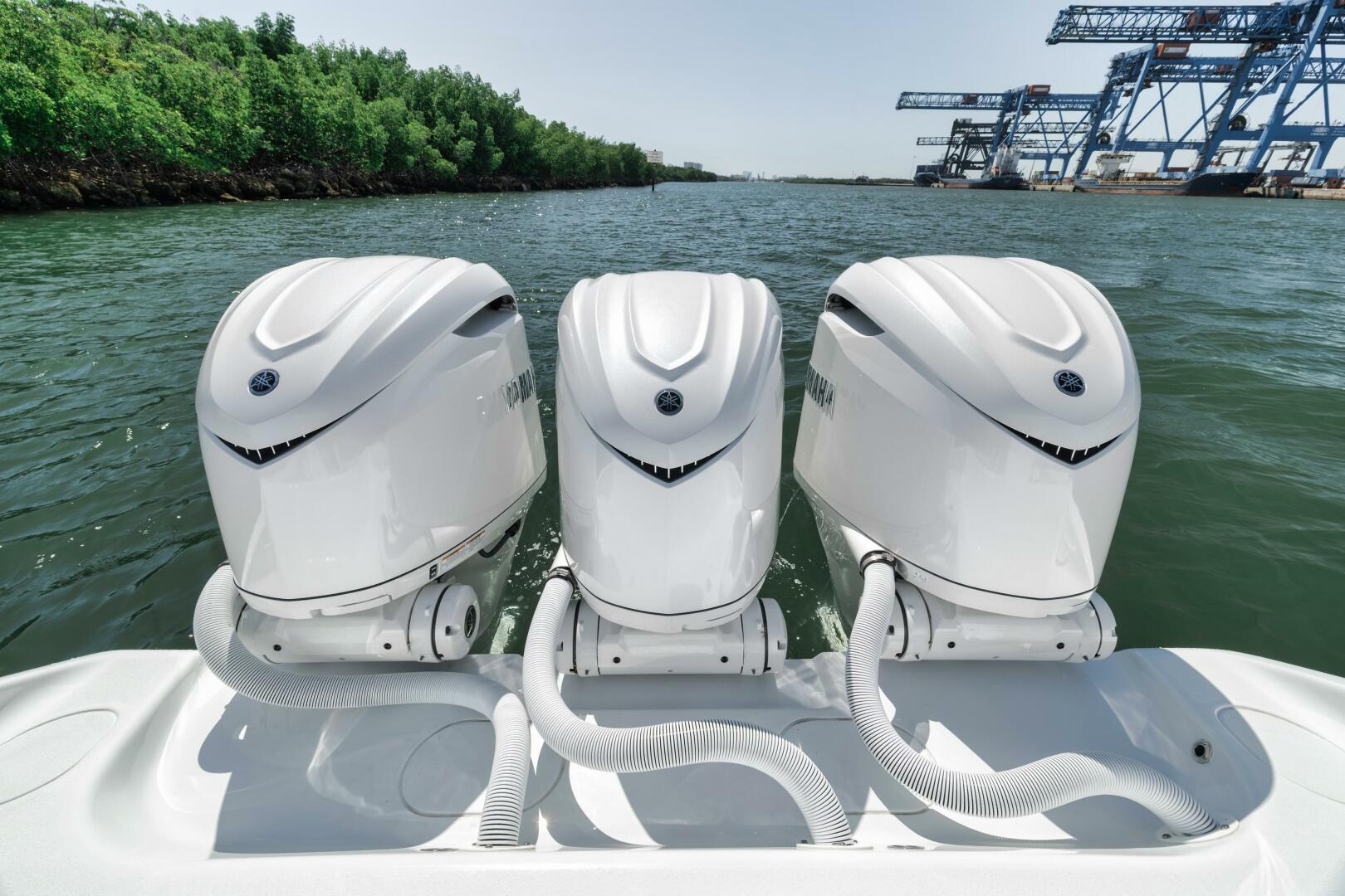 Yellowfin-36 Offshore 2025-36 Offshore FL-US-Triple outboard engines on a 2025 Yellowfin 36 Offshore boat, docked near industrial cranes.-9817861 | Thumbnail