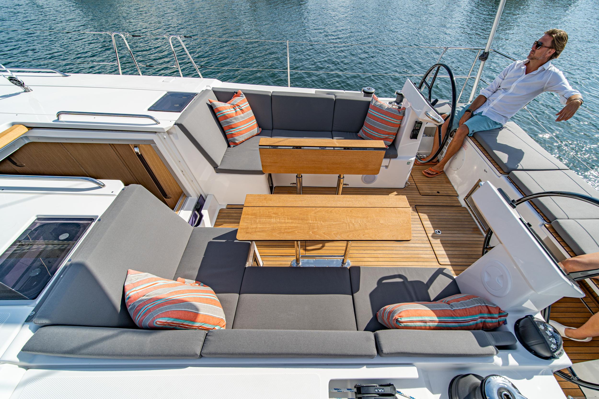 Bavaria-C45 2024-In stock and availabe now CA-US-2024 Bavaria C45 yacht deck with seating, tables, and striped cushions, overlooking the water.-9712200 | Thumbnail