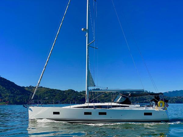 2016 Jeanneau 54 sailboat cruising on calm waters under a clear blue sky.