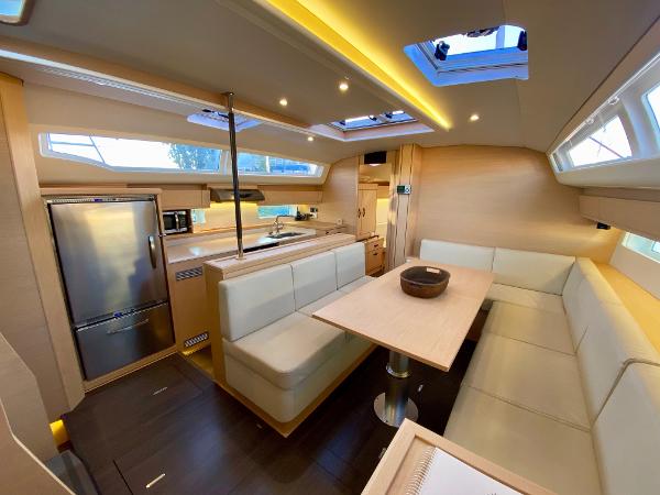 Luxurious interior of a 2016 Jeanneau 54 yacht with modern kitchen and seating area.