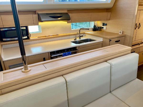 Modern kitchen interior of 2016 Jeanneau 54 yacht with sleek cabinetry and appliances.