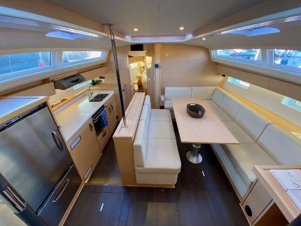 Luxurious interior of a 2016 Jeanneau 54 yacht with modern kitchen and seating area.