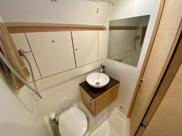 Compact bathroom in a 2016 Jeanneau 54 yacht with modern fixtures and storage.