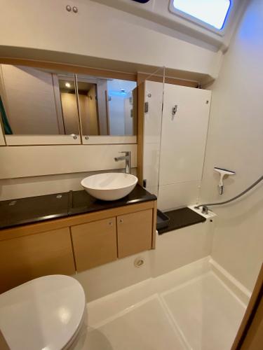 Modern bathroom in a 2016 Jeanneau 54 yacht with sleek fixtures and ample storage.