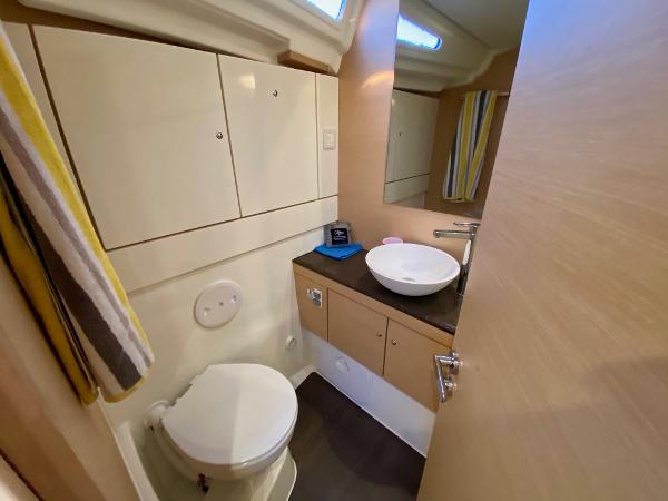 Bathroom interior of 2016 Jeanneau 54 yacht with modern fixtures and storage cabinets.
