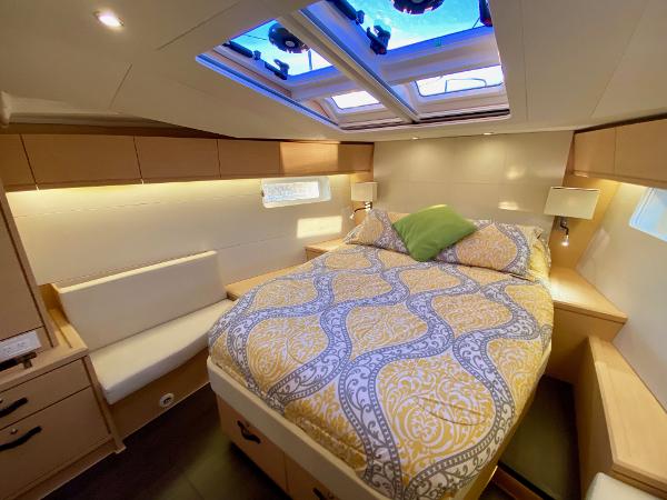 Luxurious cabin interior of a 2016 Jeanneau 54 yacht with skylight and cozy bedding.