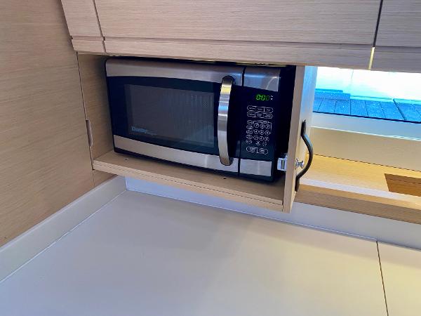 Microwave in Jeanneau 54 yacht kitchen, 2016 model, with light wood cabinetry.