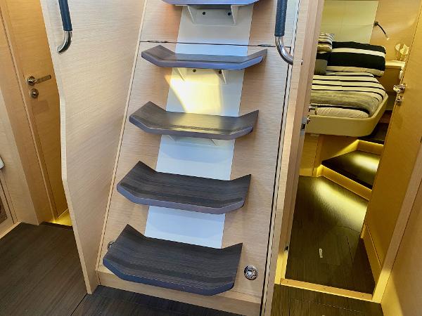 Interior stairs of a 2016 Jeanneau 54 yacht, leading to a cozy cabin.