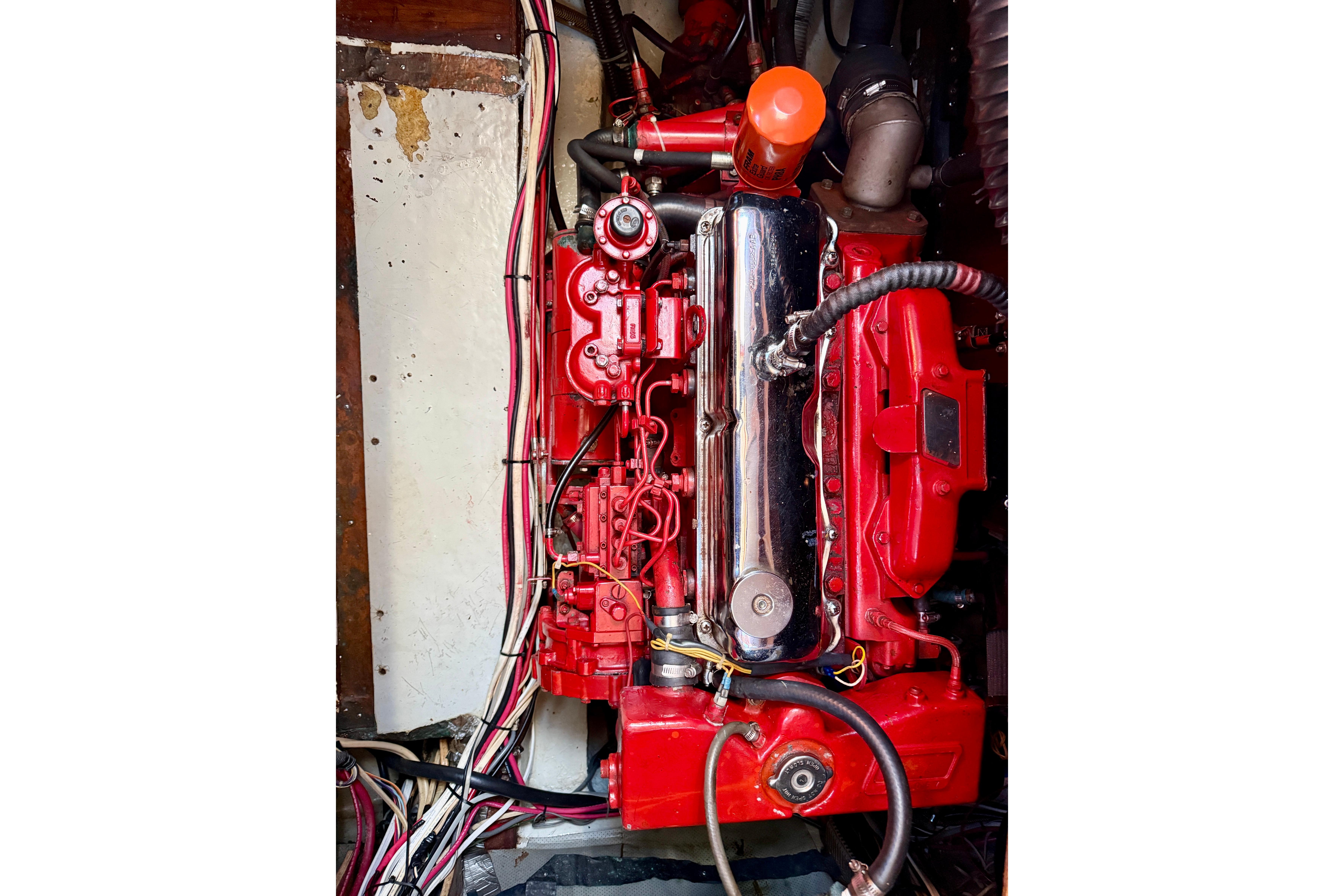 Engine of a 1986 Nauticat 43 sailboat, featuring red components and wiring.