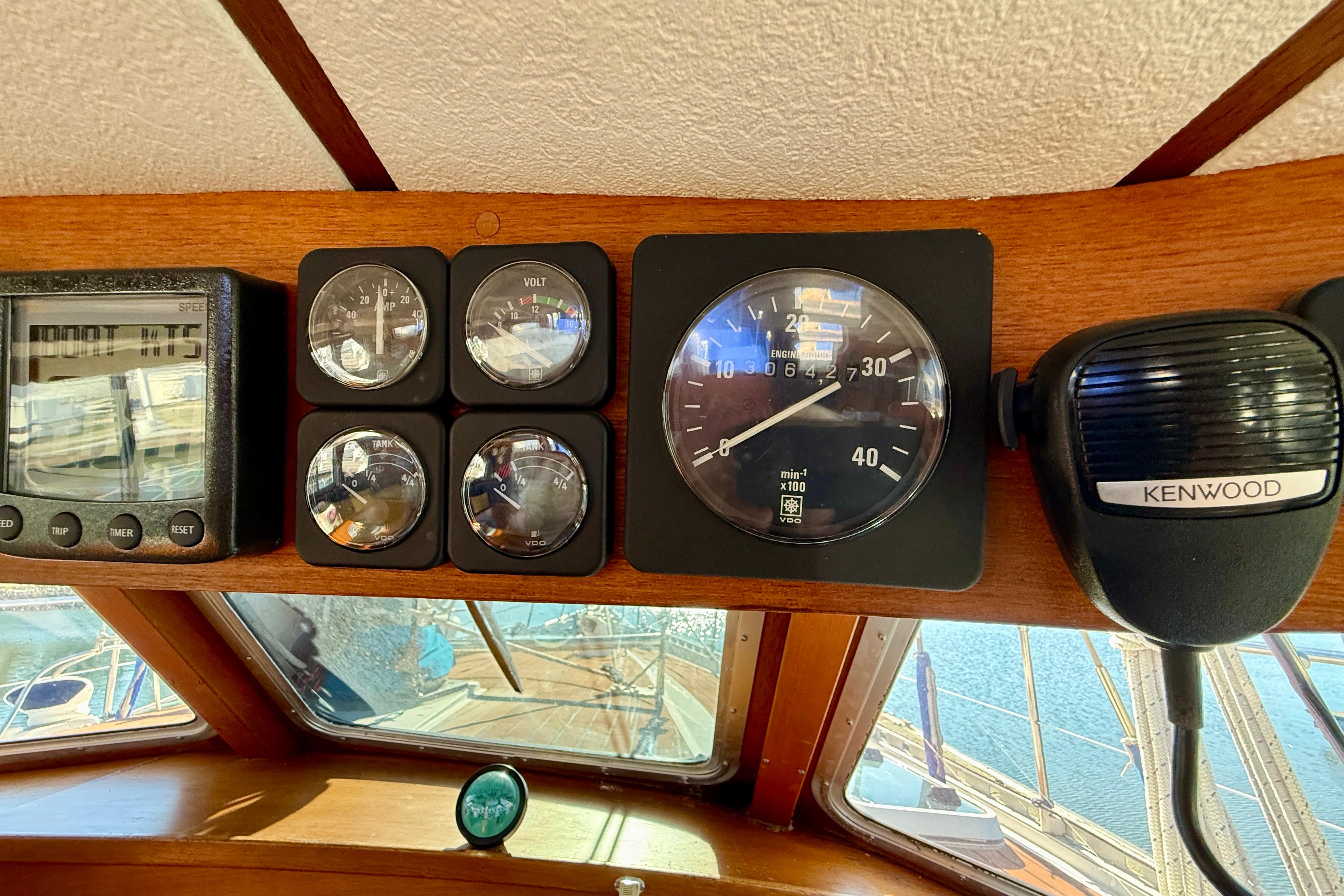 Control panel of a 1986 Nauticat 43 sailboat with gauges and Kenwood radio.