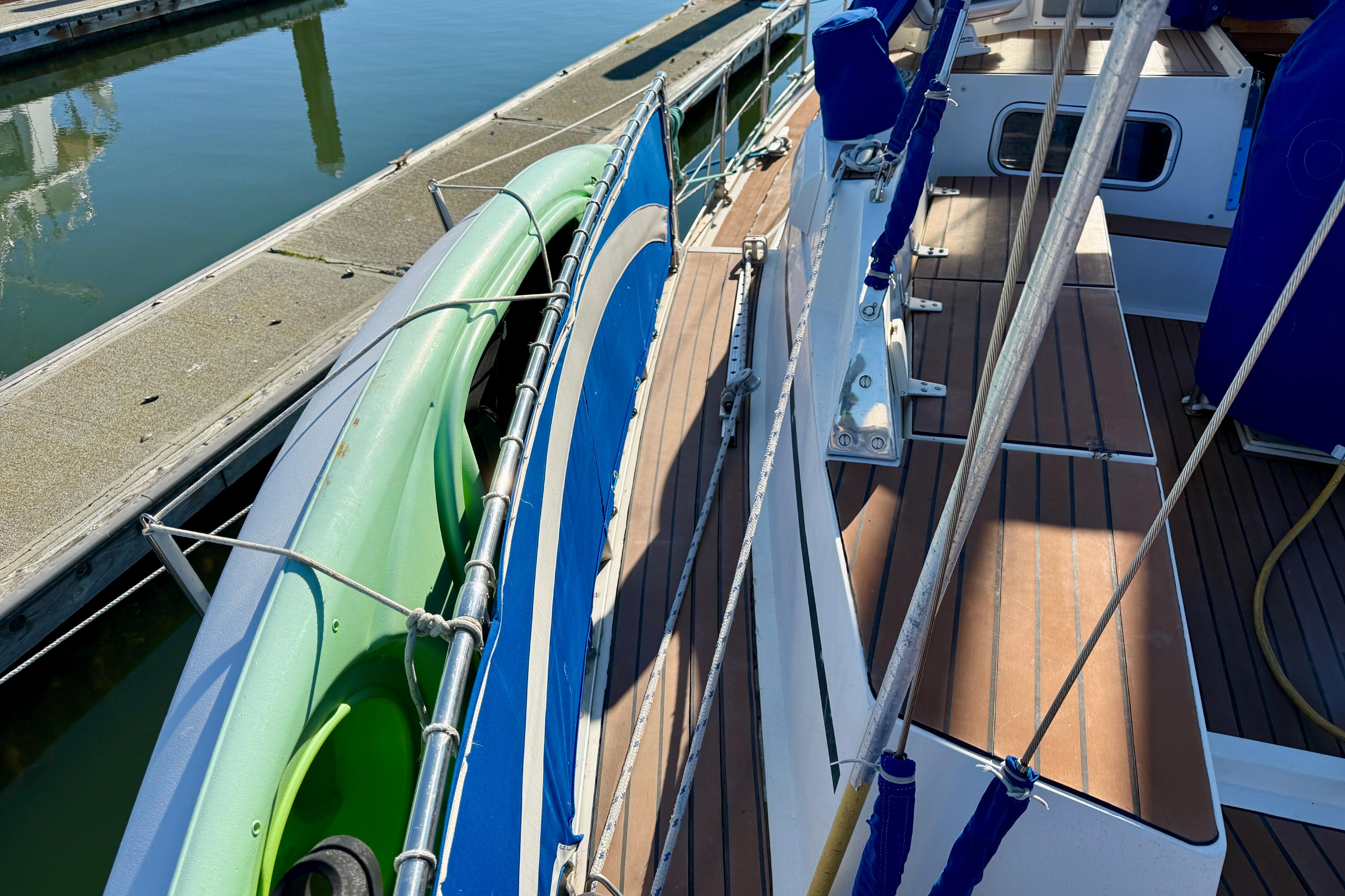 1986 Nauticat 43 sailboat deck with green kayak, docked at marina.