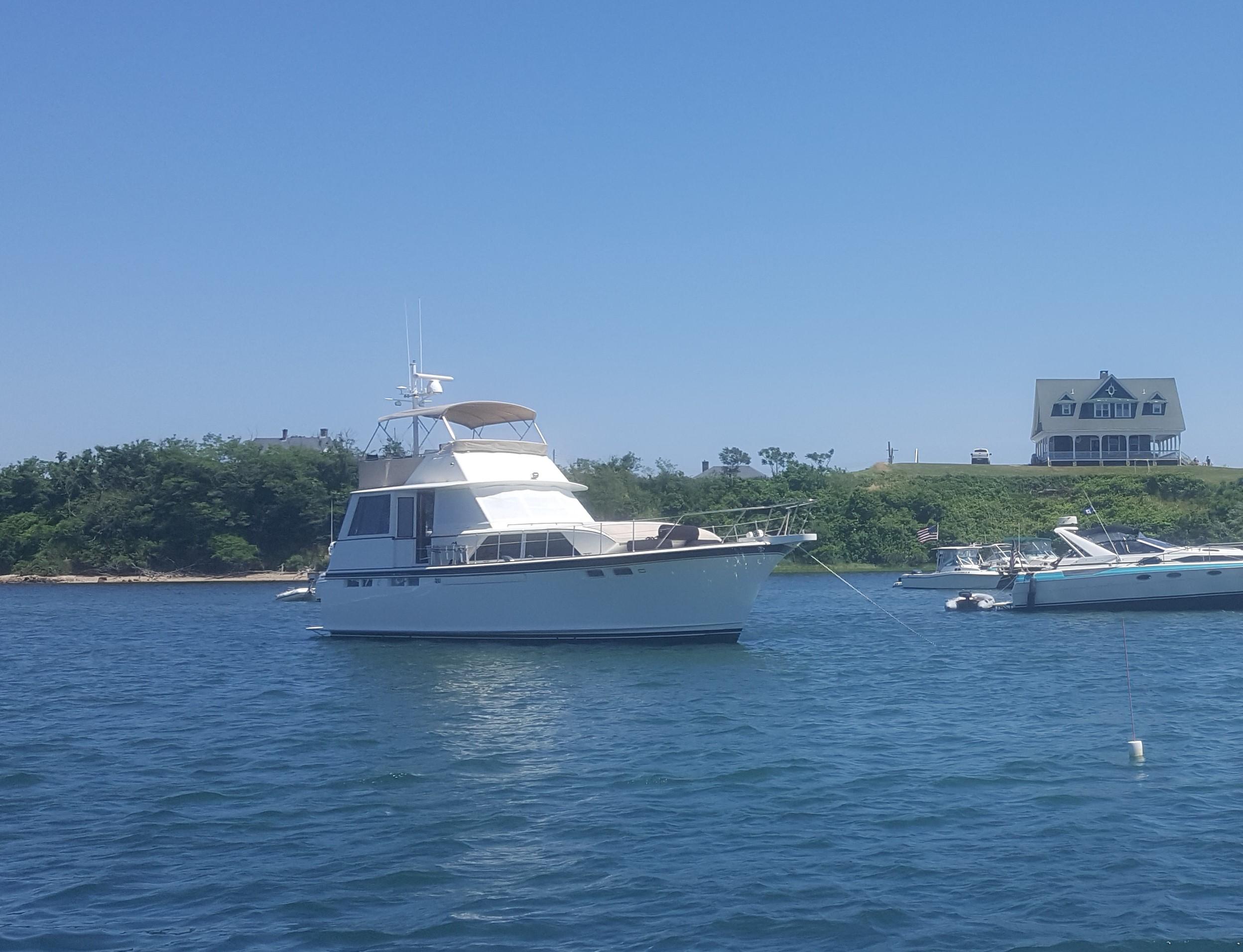 1973 Chris-Craft 47 Commander Flush Deck yacht anchored in a scenic bay.