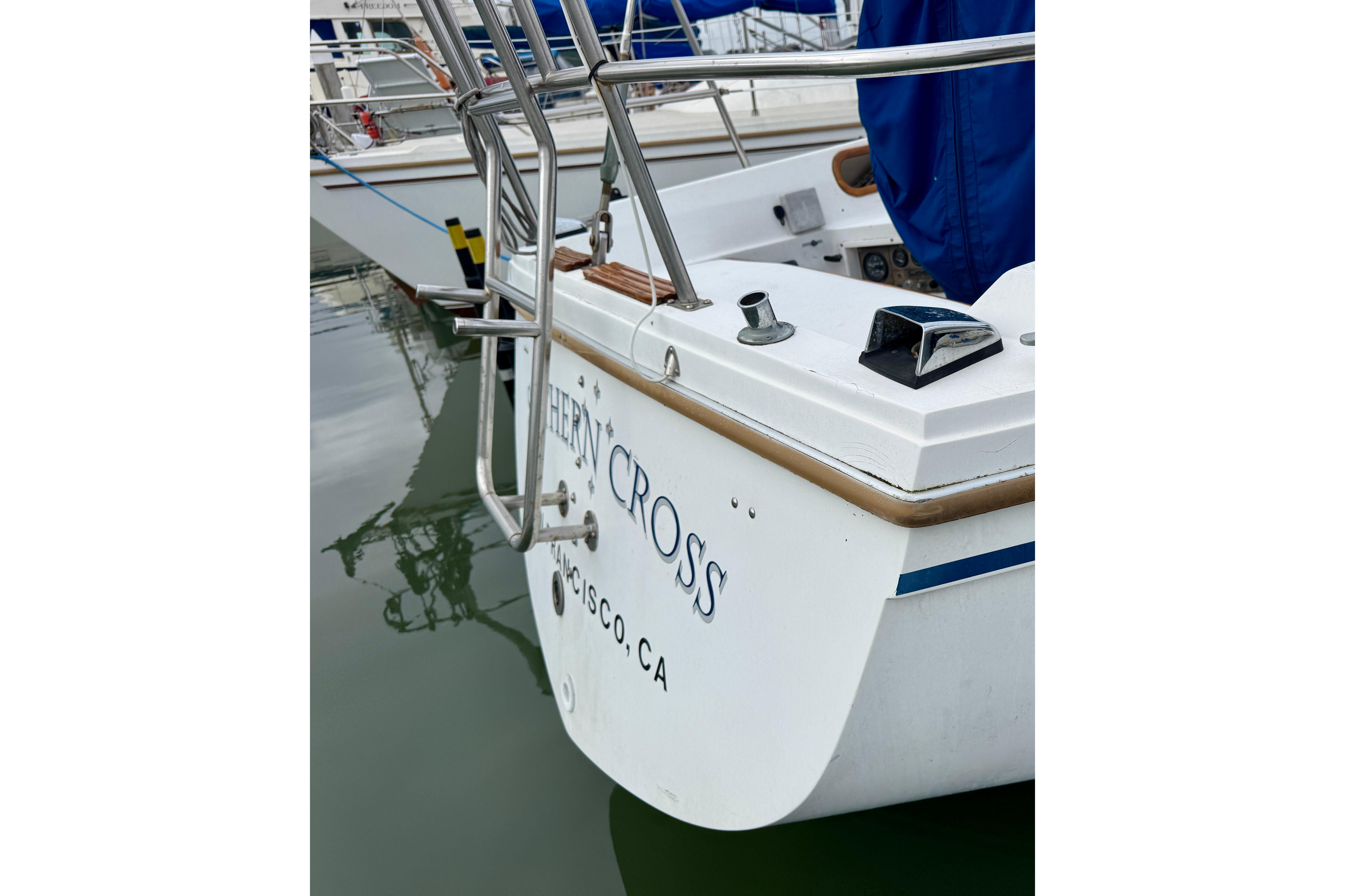 1986 Catalina 36 sailboat stern view in marina, featuring stainless steel railings.
